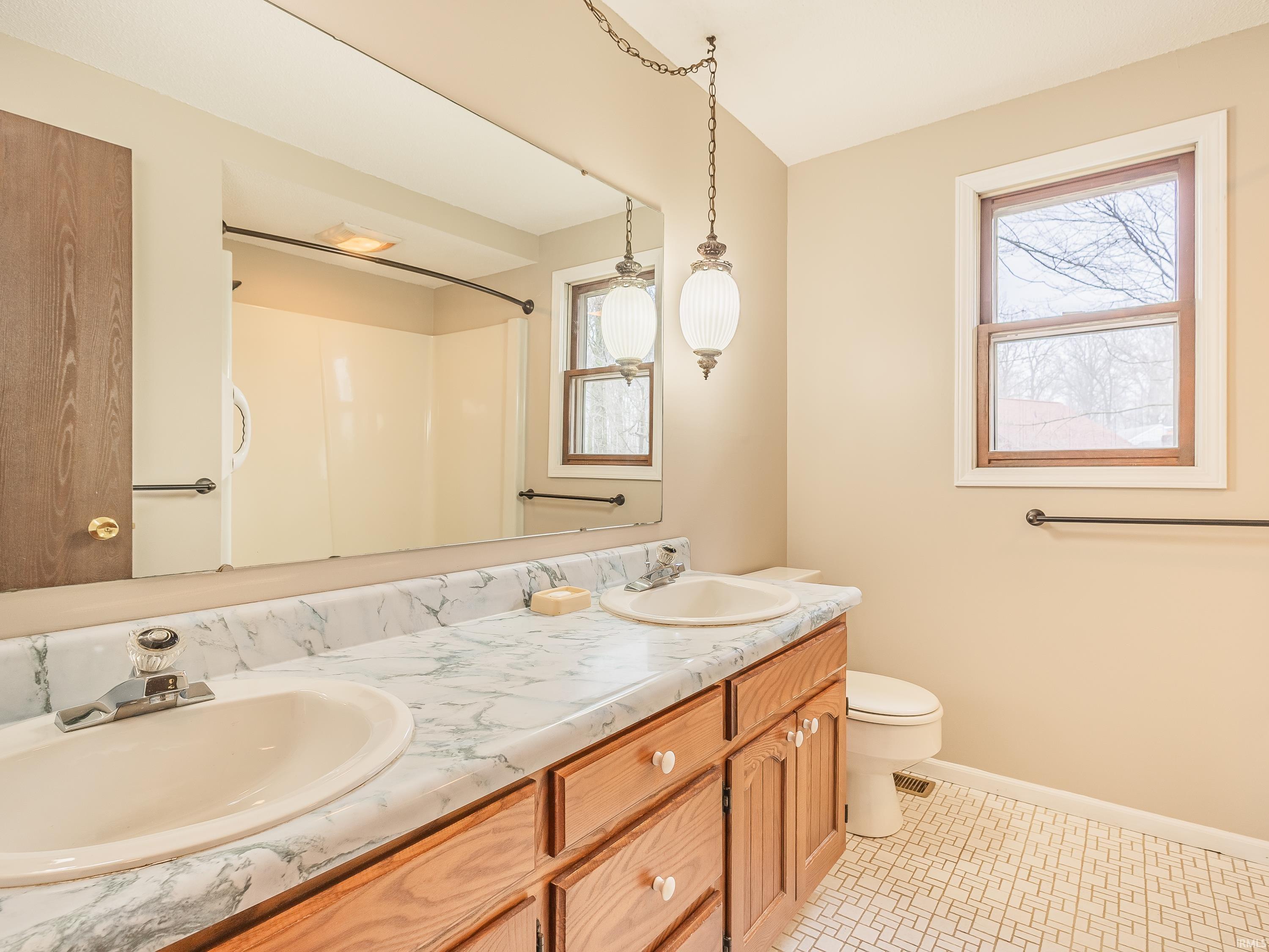 Hallway bath featuring double vanity and a shower/tub