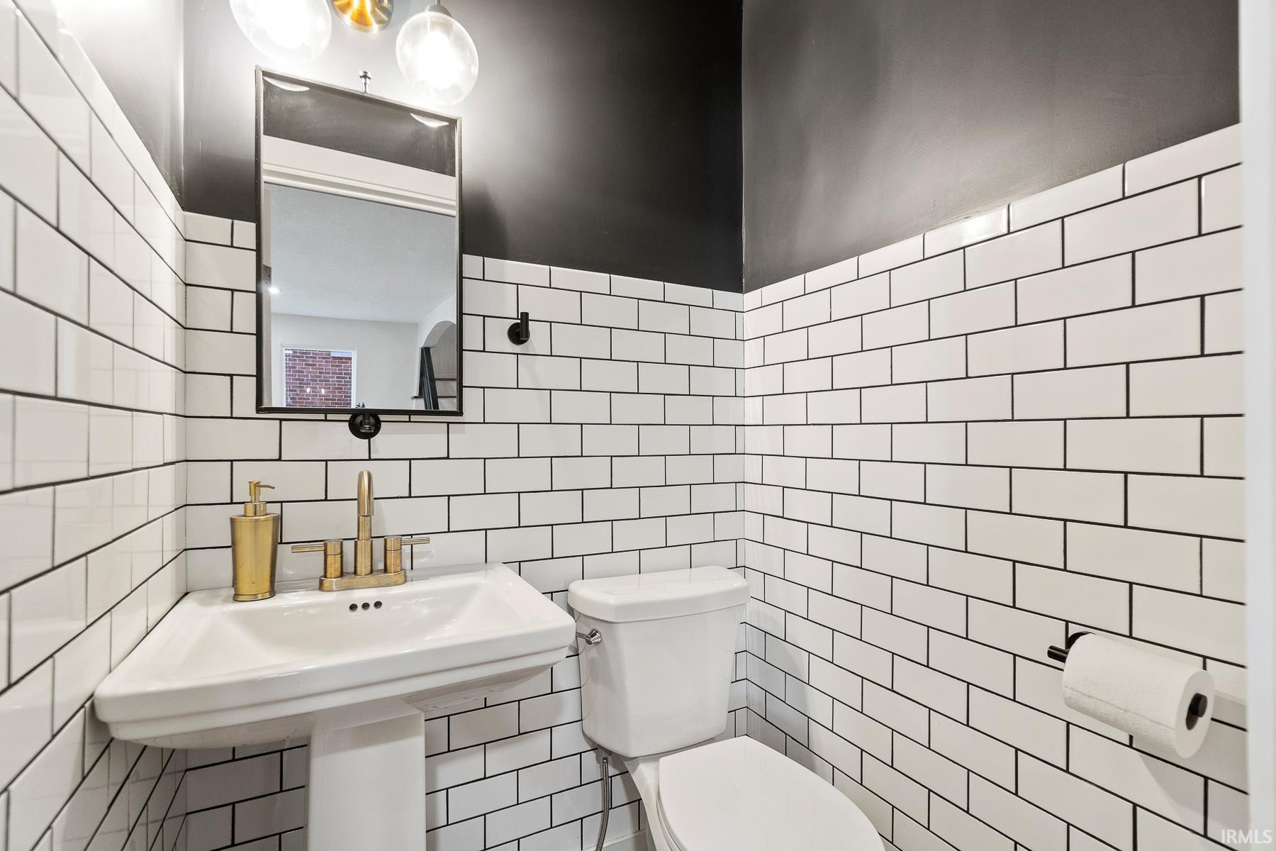 Half bath with tile walls and decorative backsplash
