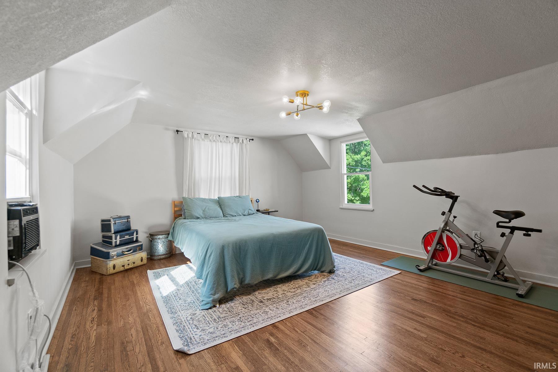 Bedroom with wood finished floors and a chandelier