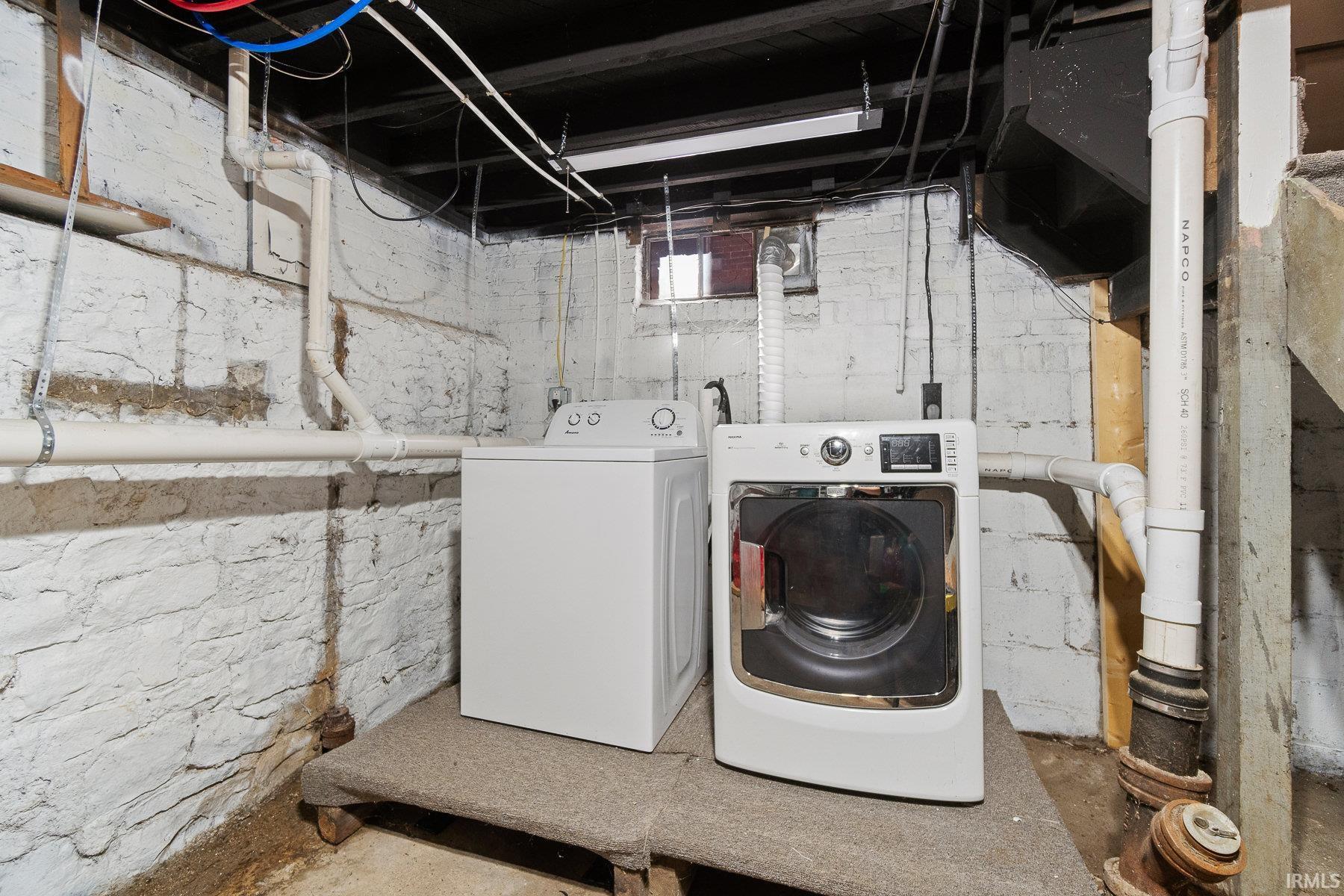 Laundry area featuring washer and dryer and concrete flooring