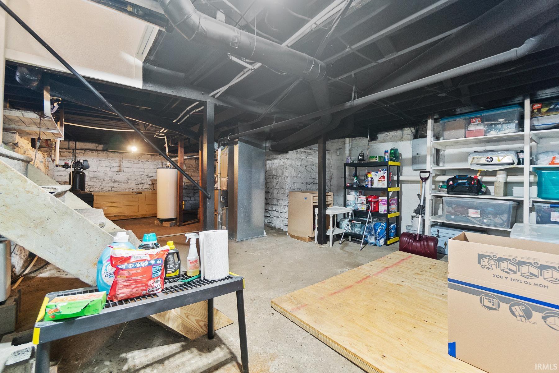 Unfinished basement with water heater and electric panel