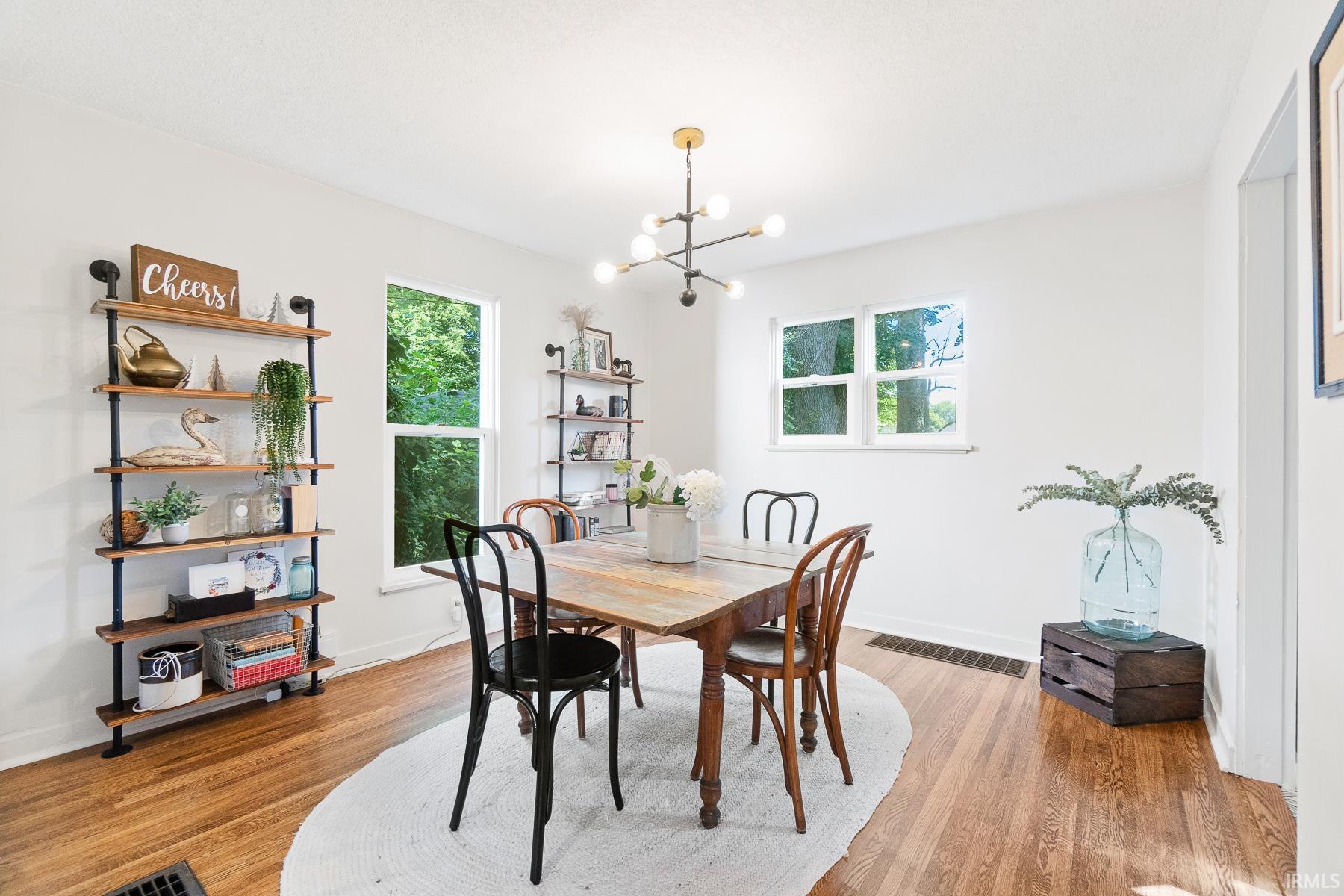 Dining room featuring suspended lighting, plenty of natural light, and light wood-style flooring