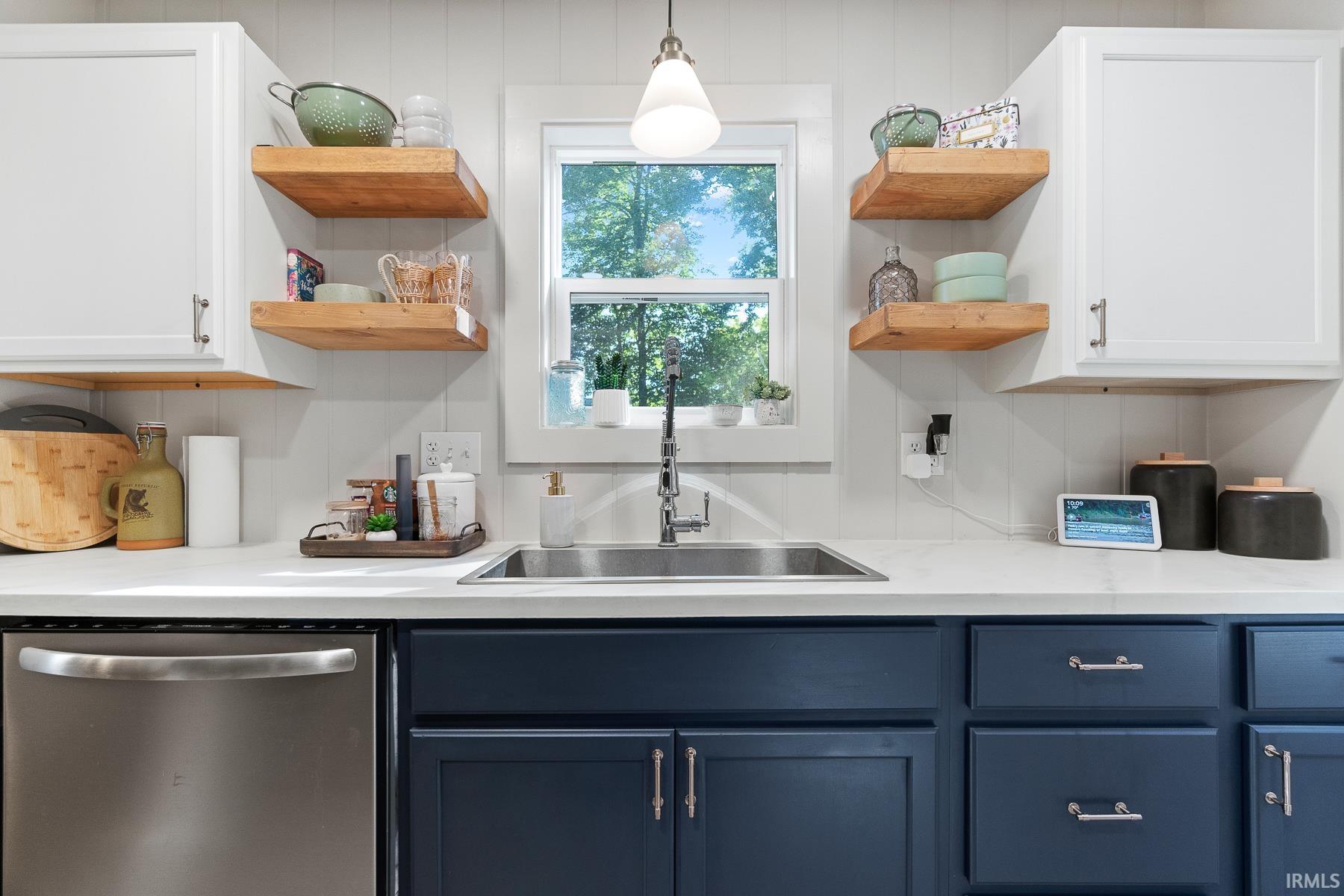 Dual tone kitchen featuring open shelves, dishwasher, two tone cabinets, and hanging light fixtures