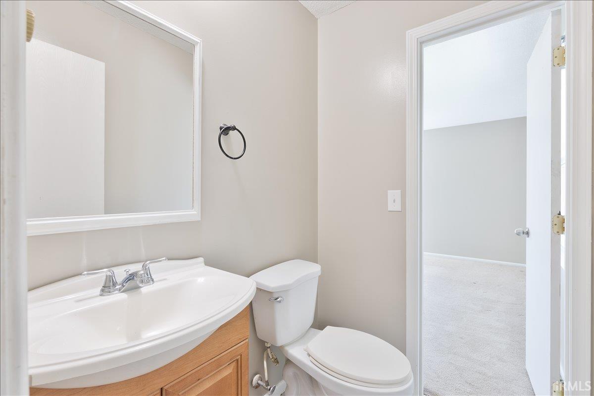 Half bath featuring vanity and carpet floors