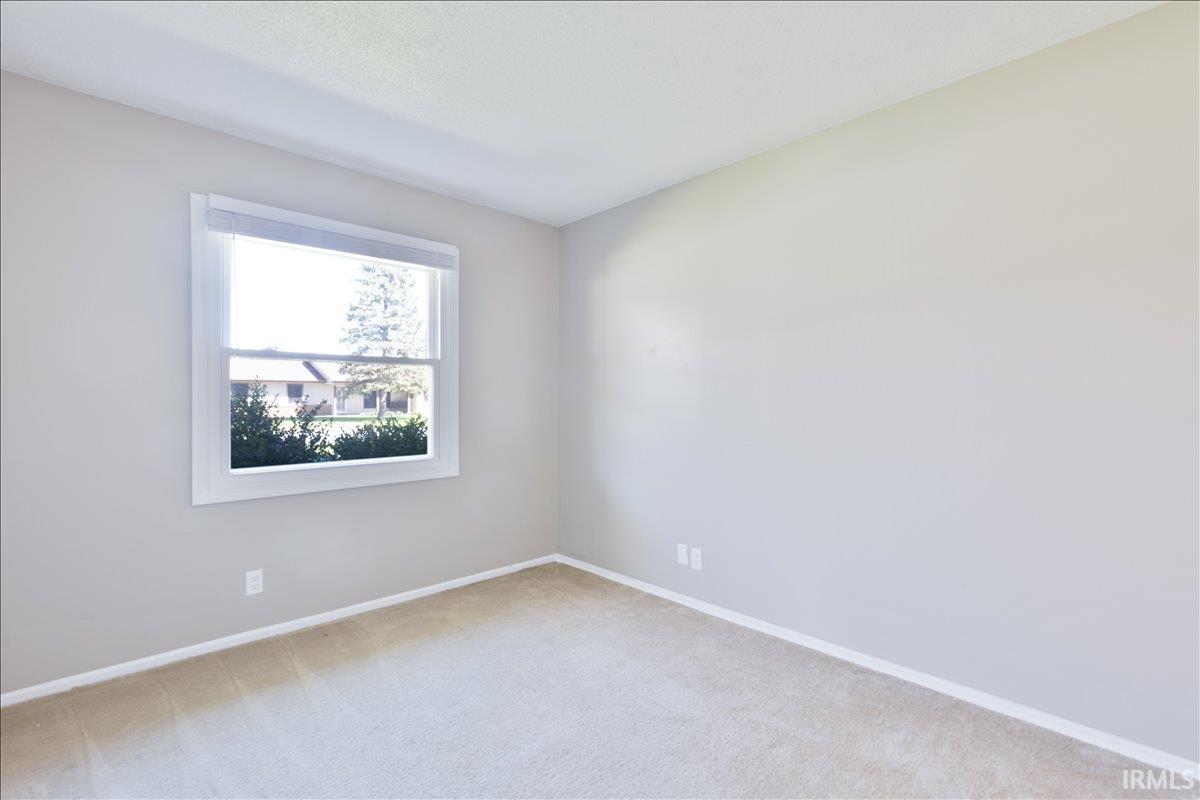 Unfurnished room with light carpet and baseboards