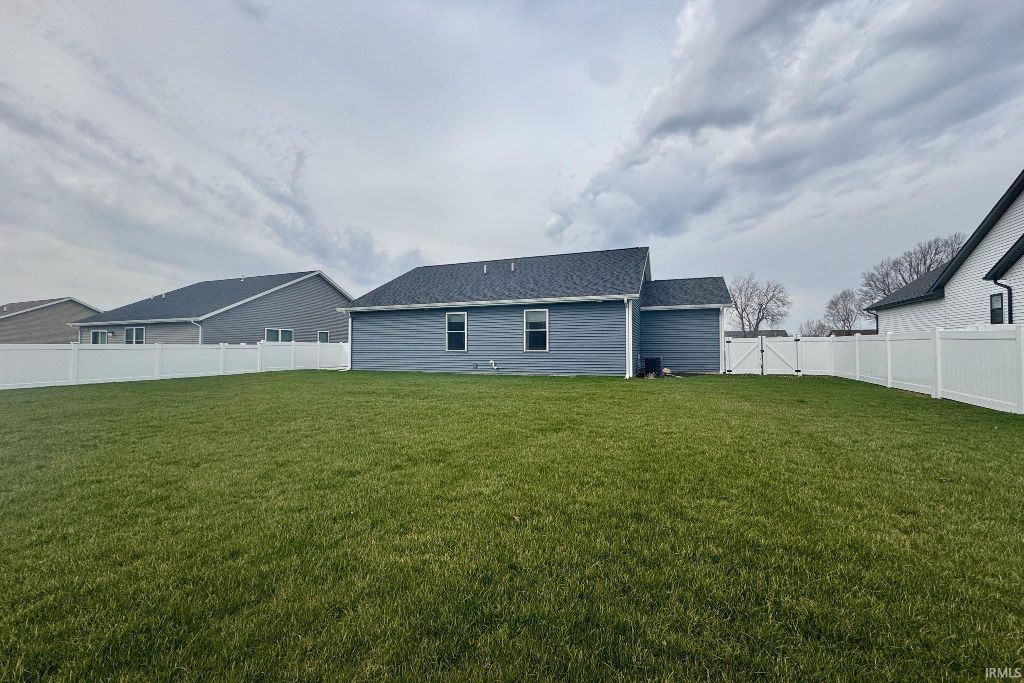 Back of property with a gate and a fenced backyard