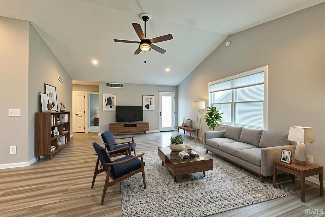 Vaulted ceiling with a ceiling fan, recessed lighting, wood-finish flooring, and a large window