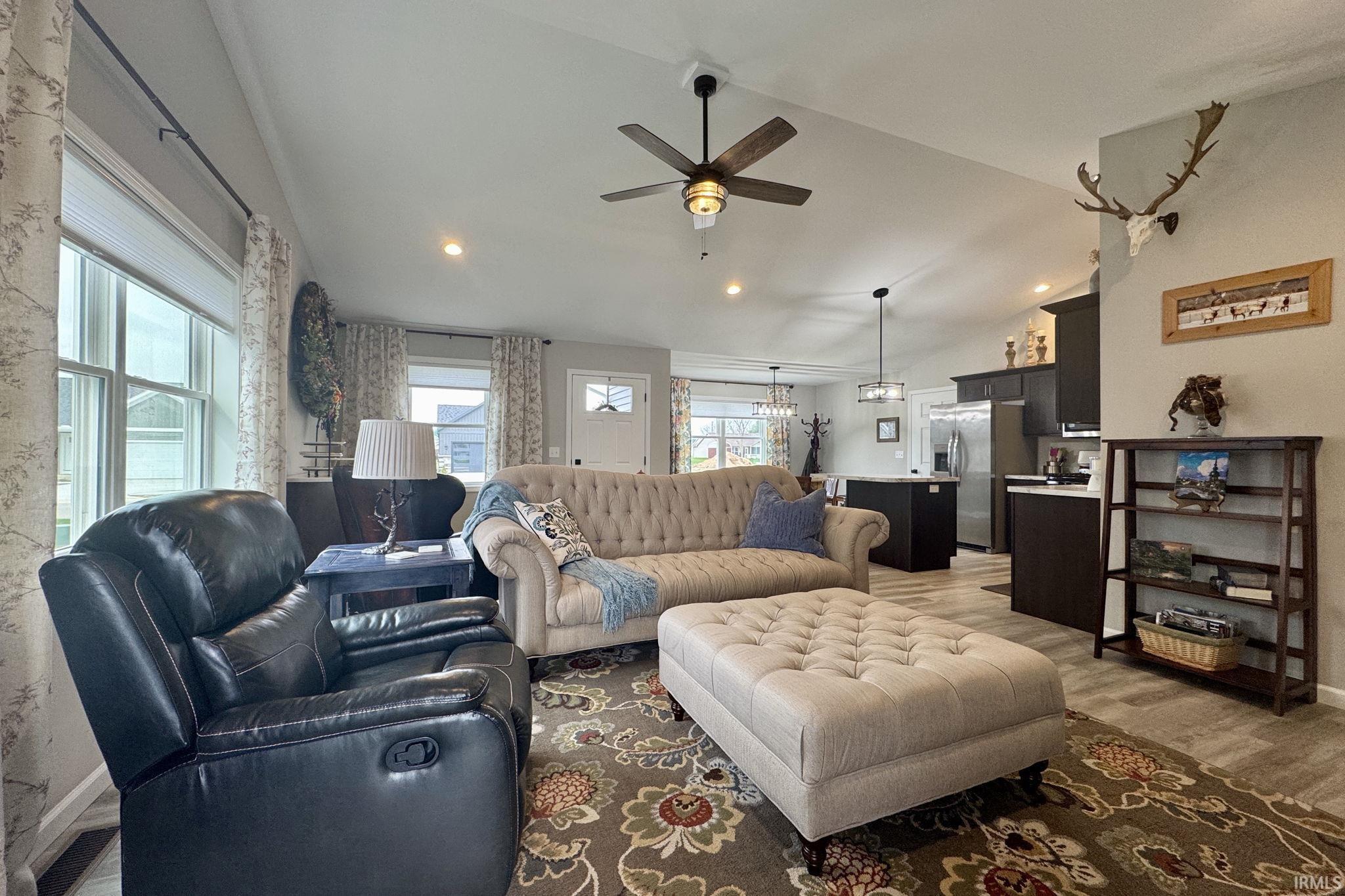 Living room with ceiling fan, lofted ceiling, wood finished floors, and recessed lighting