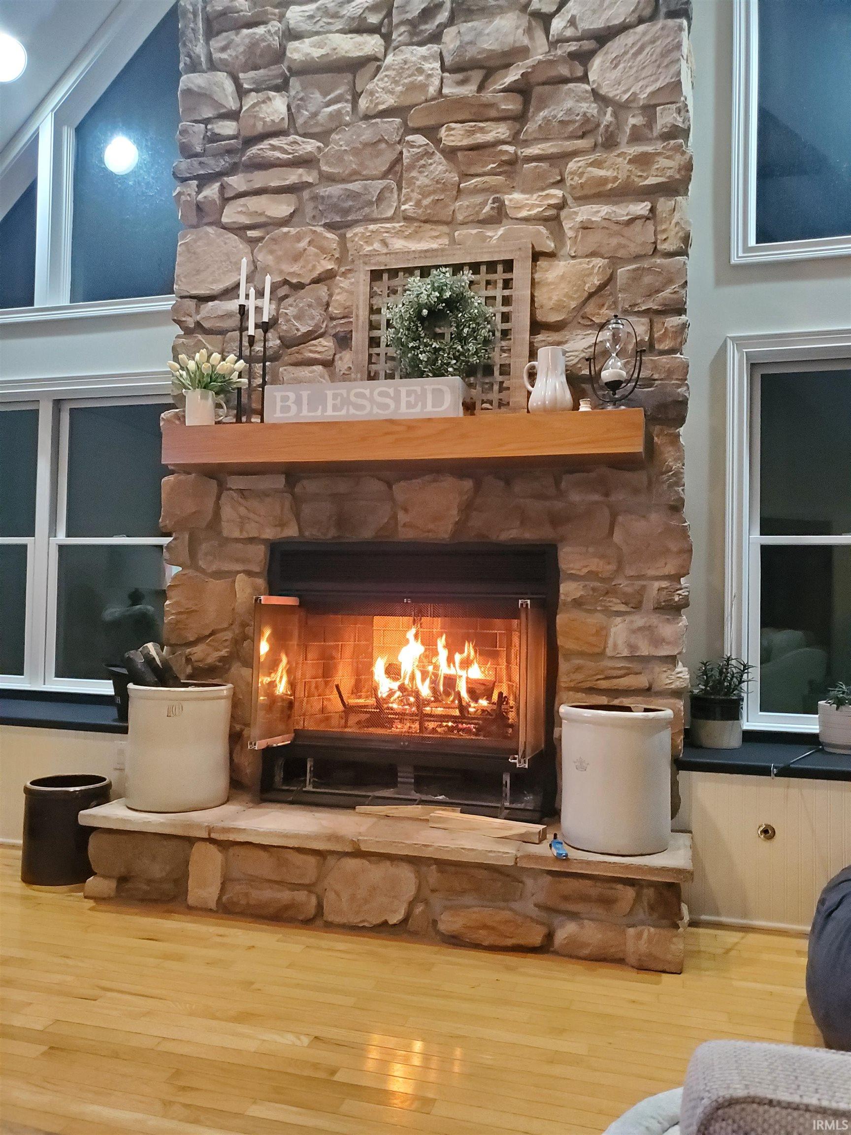 Detailed view of a woodburning fireplace and wood finished floors