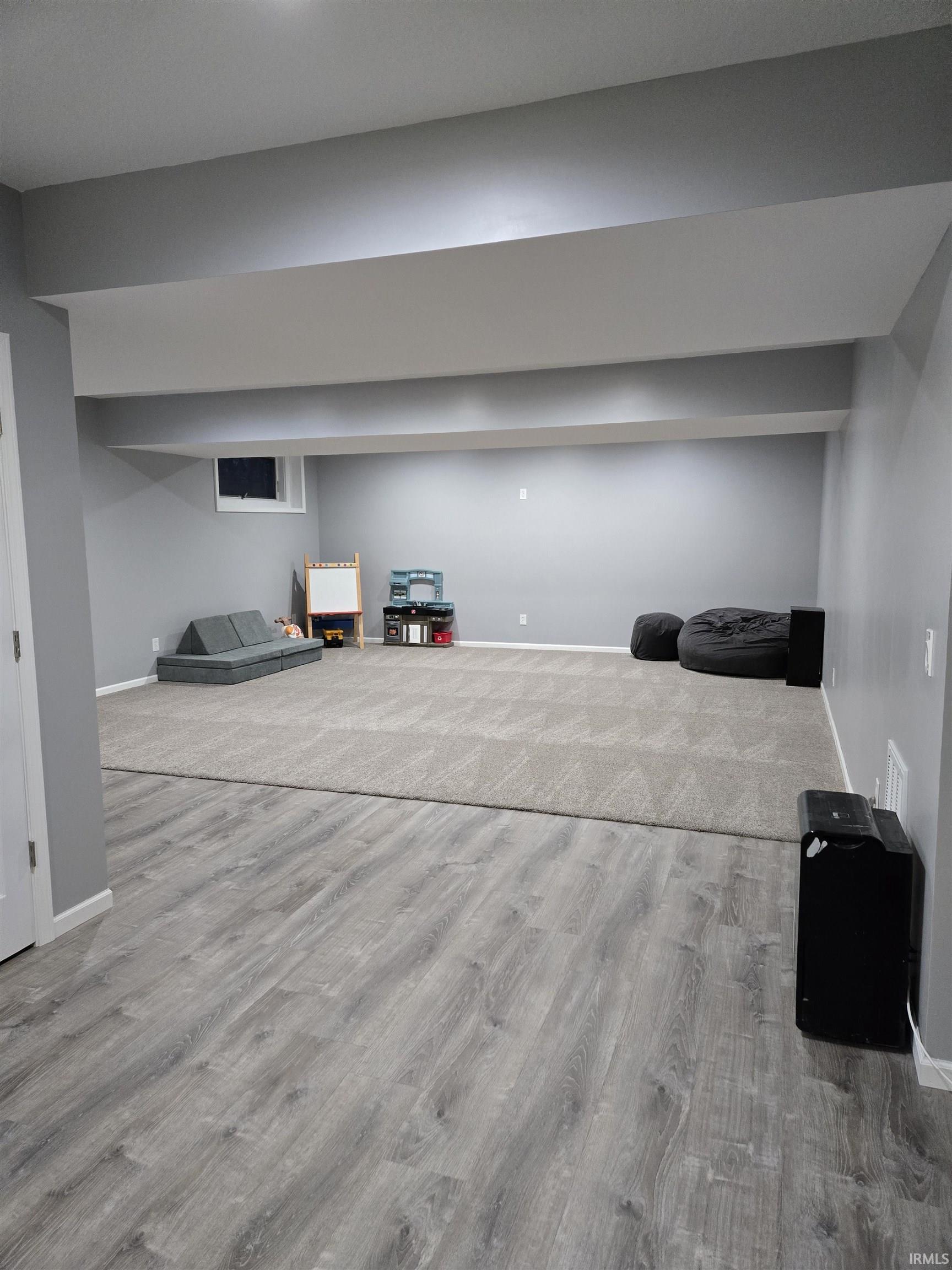Finished basement featuring baseboards and light wood-style flooring