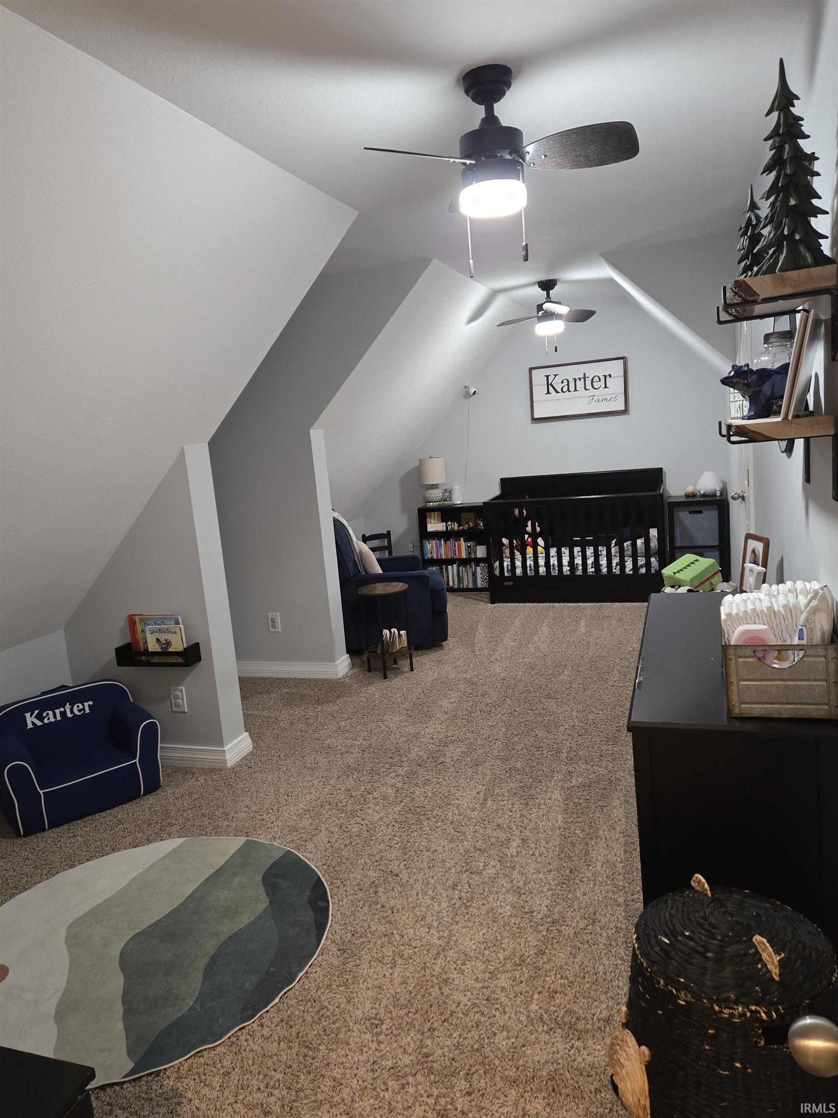 Bedroom featuring lofted ceiling, carpet, a nursery area, and ceiling fan