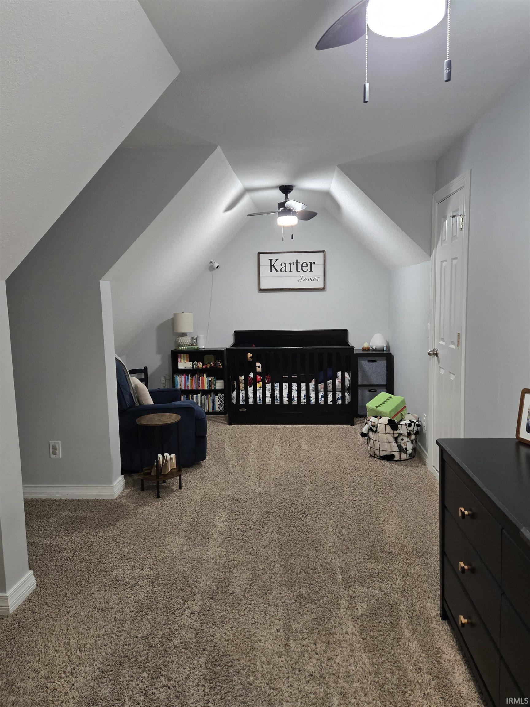 Bedroom featuring carpet flooring, vaulted ceiling, and a ceiling fan