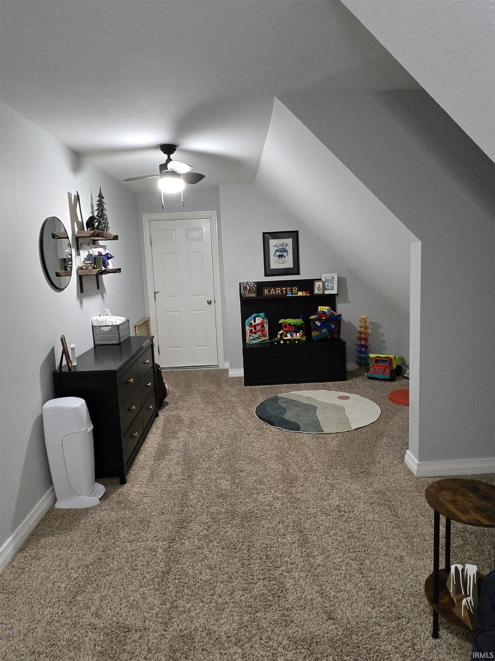 Playroom featuring a ceiling fan, light colored carpet, and vaulted ceiling
