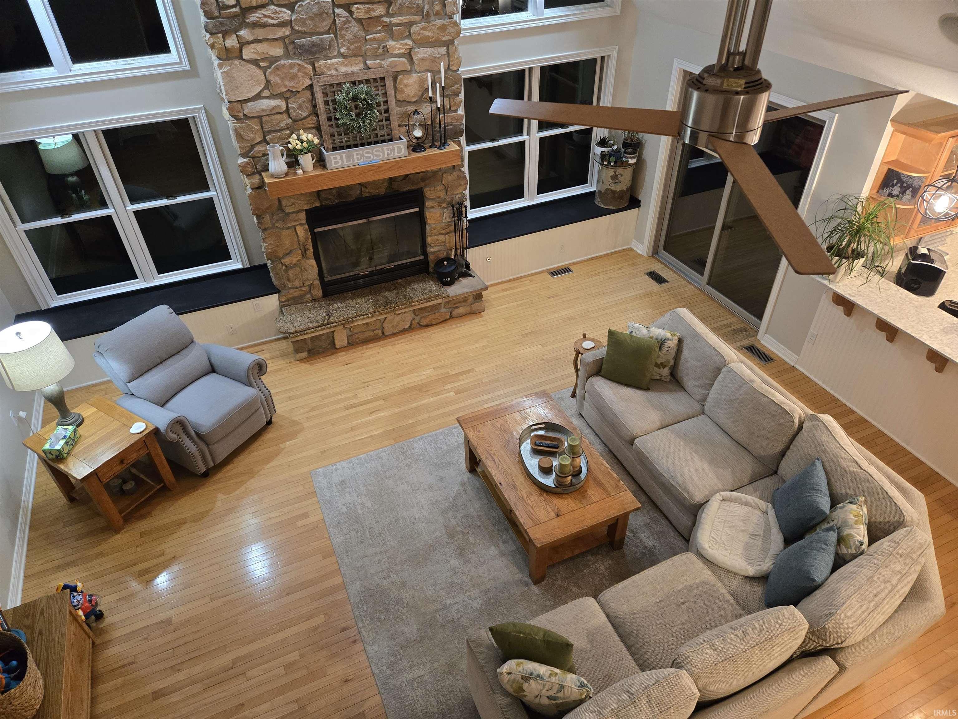 Living area with light wood-style floors and a stone fireplace