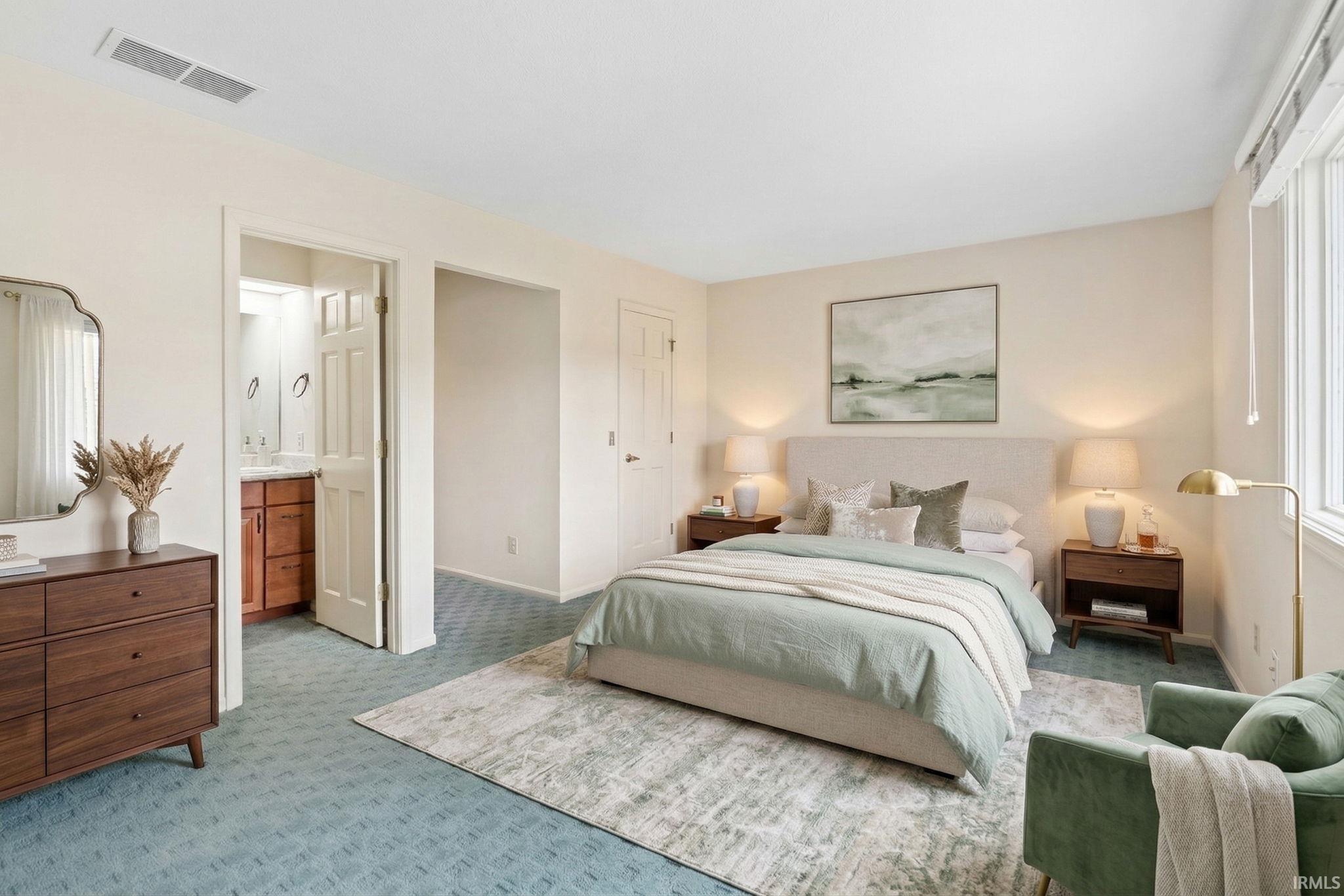 Bedroom with light colored carpet and baseboards