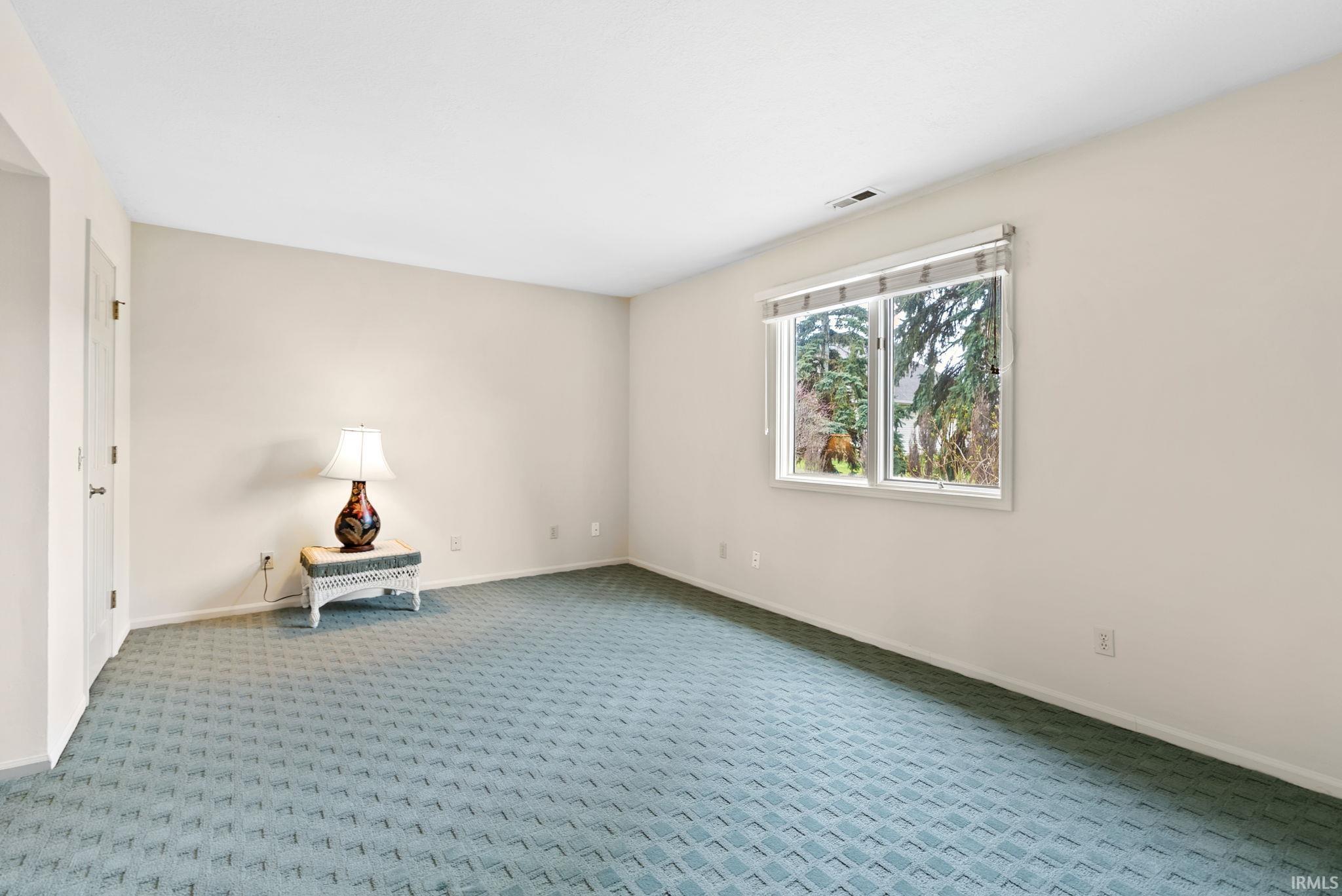 Carpeted spare room with baseboards