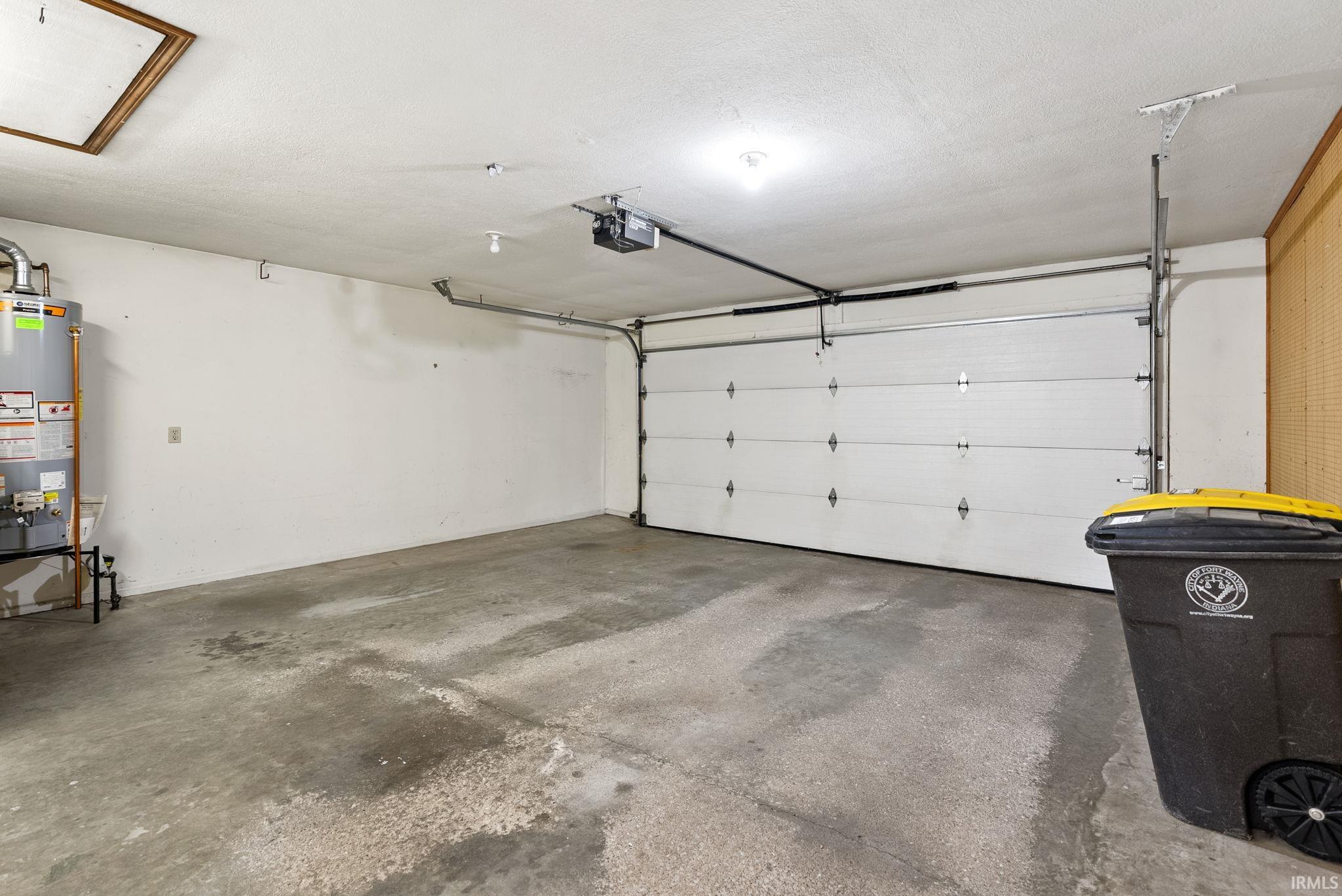 Garage with gas water heater and a garage door opener