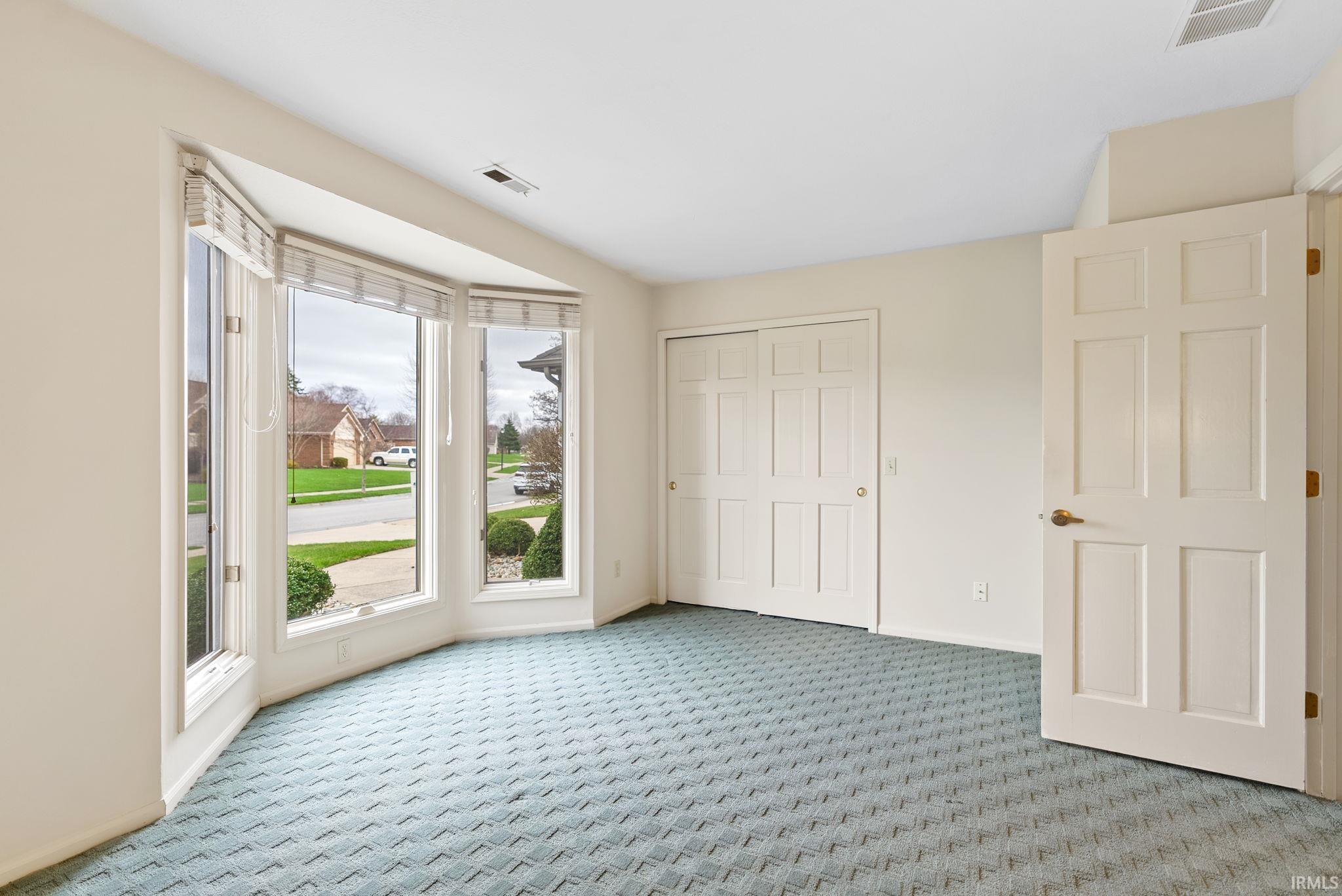 Unfurnished bedroom featuring light colored carpet and a closet