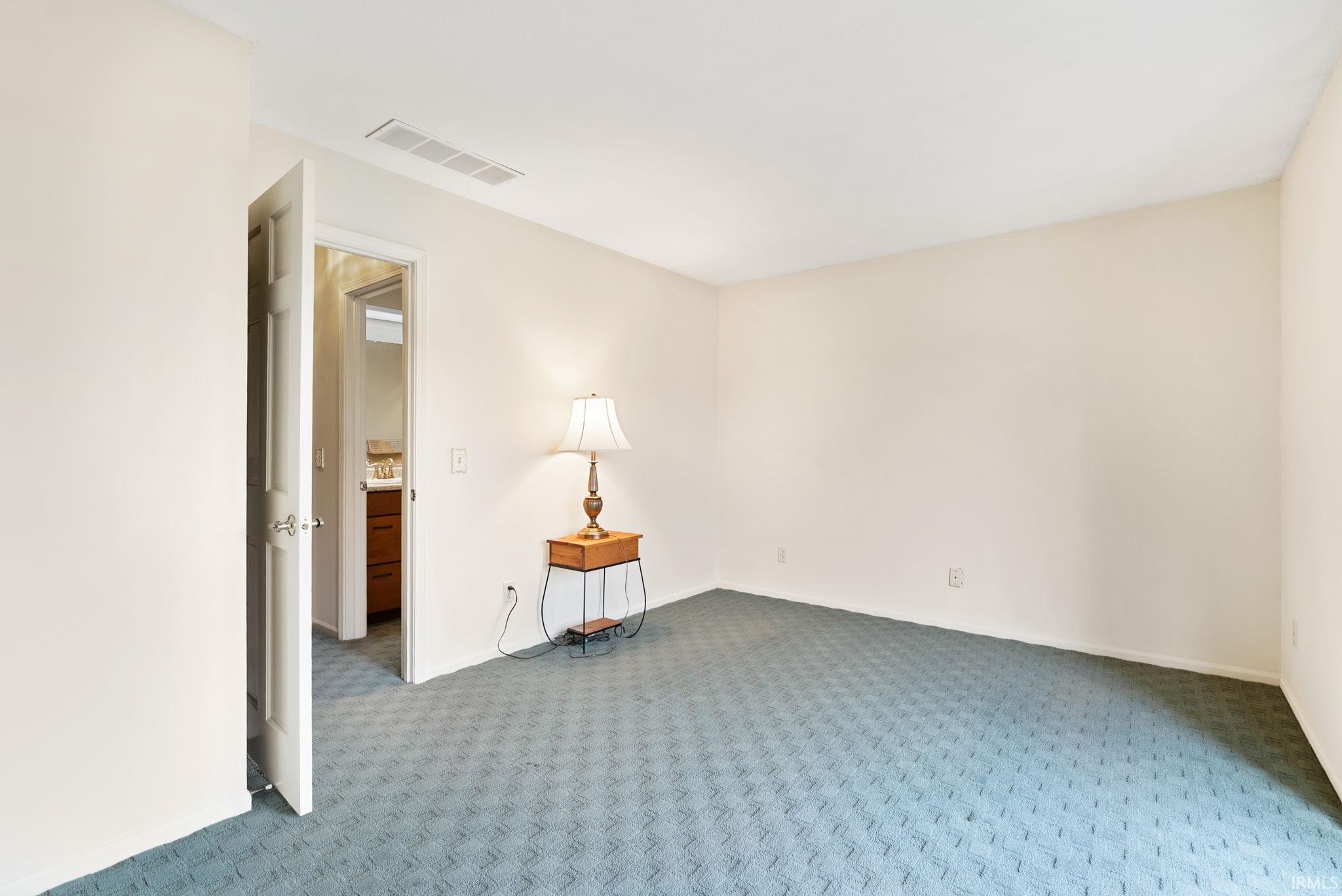 Spare room with carpet and baseboards