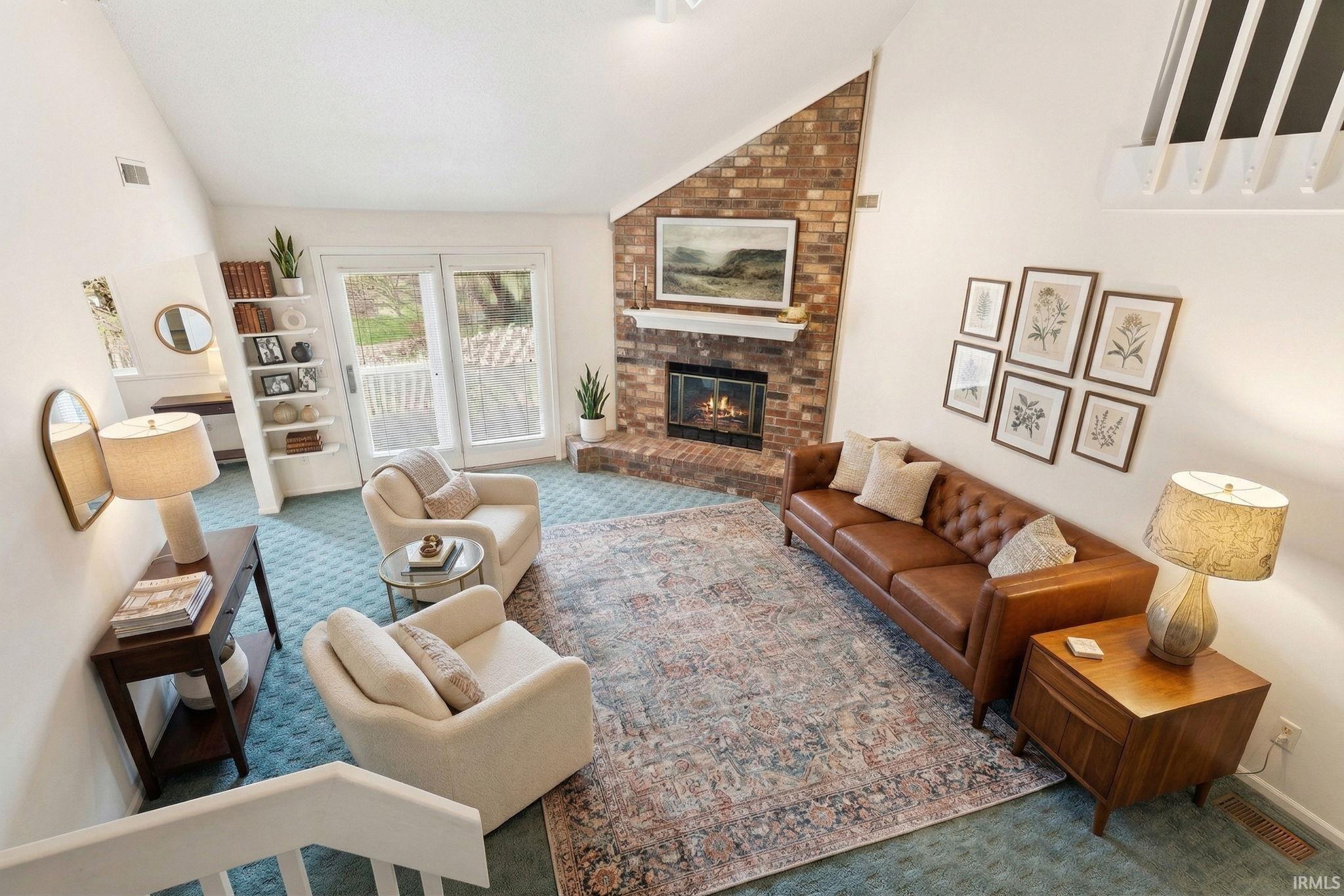 Carpeted living area featuring vaulted ceiling and a brick fireplace