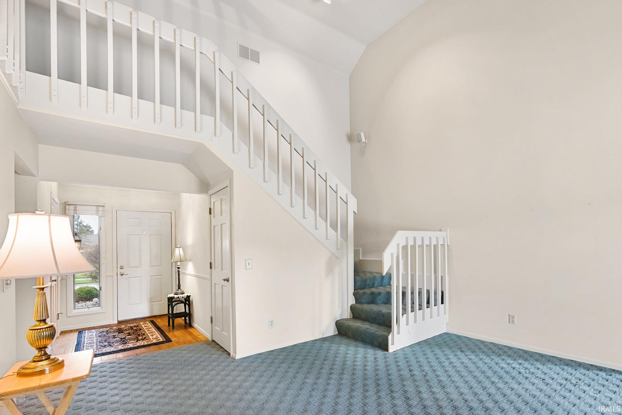 Stairway featuring carpet floors and a high ceiling