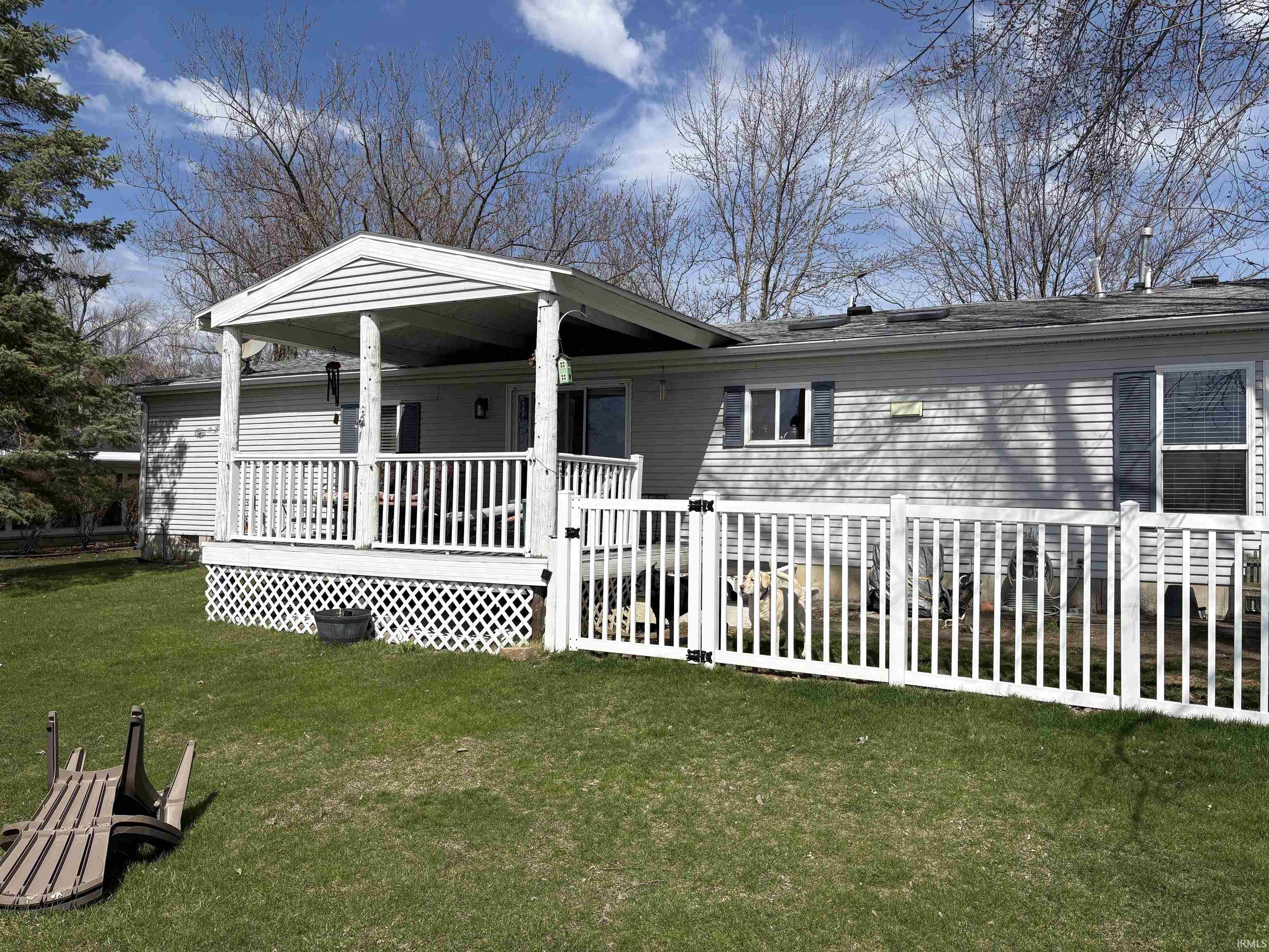 View of front of home with a deck and a front lawn