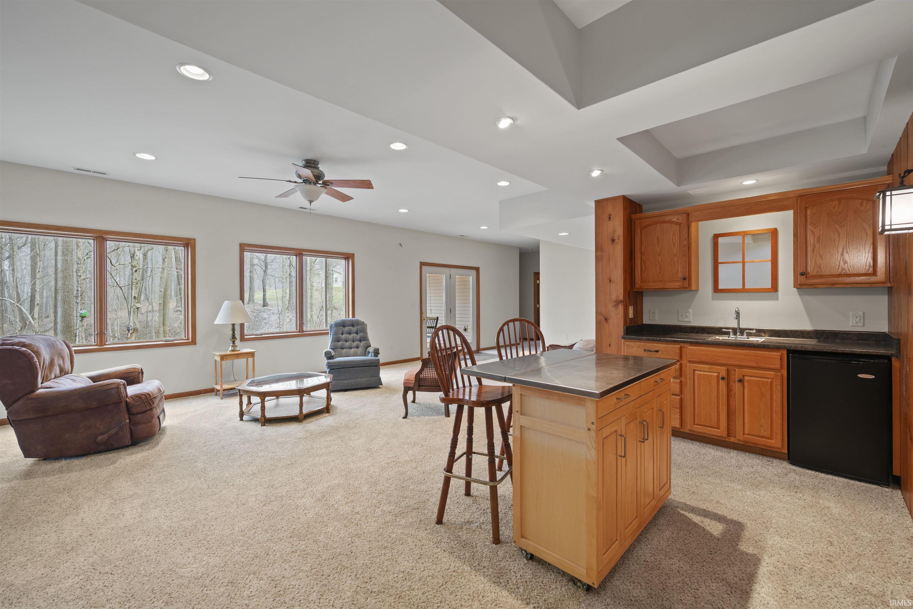 Kitchen with open floor plan, recessed lighting, black dishwasher, a kitchen bar, and ceiling fan