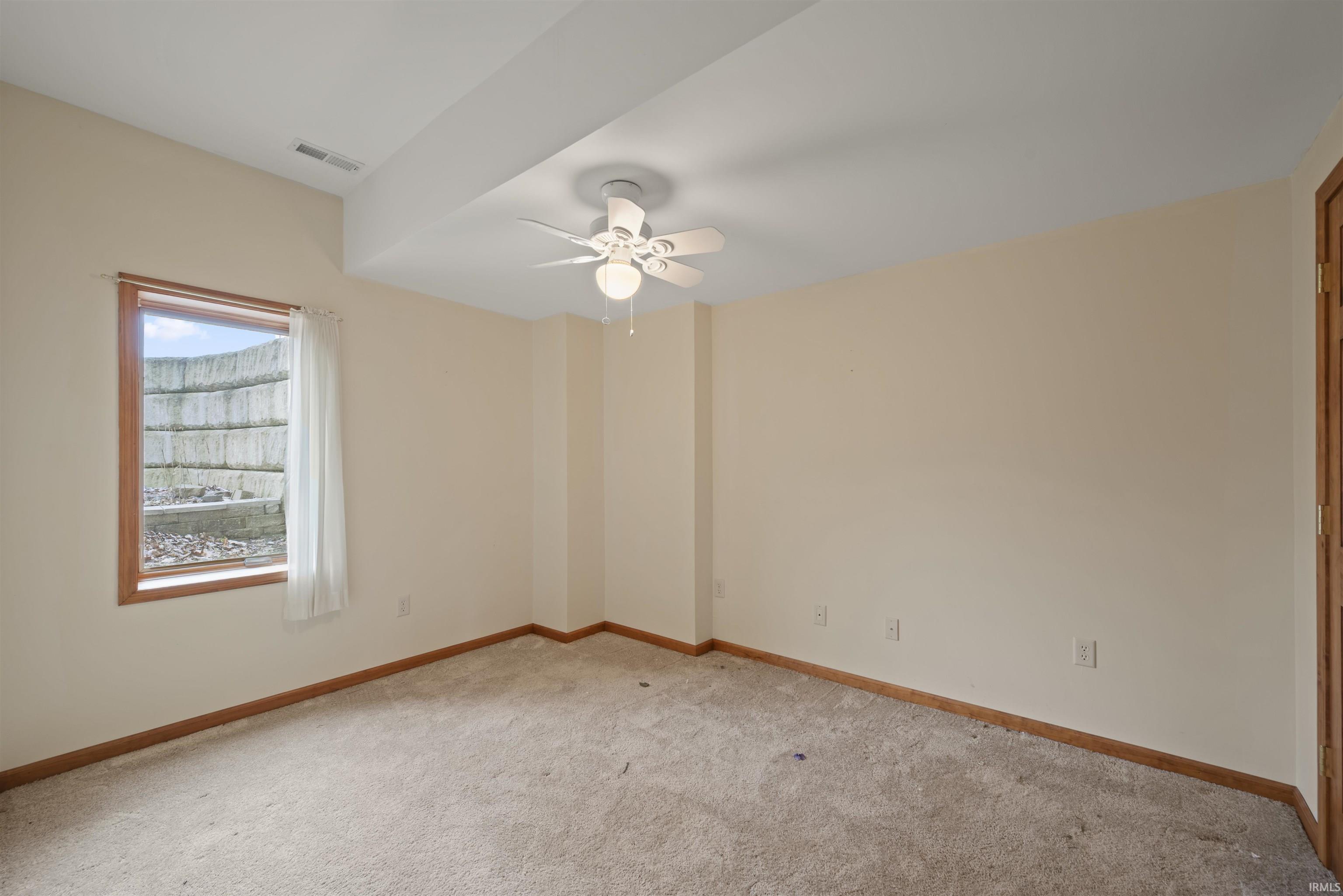 Spare room featuring light colored carpet and ceiling fan