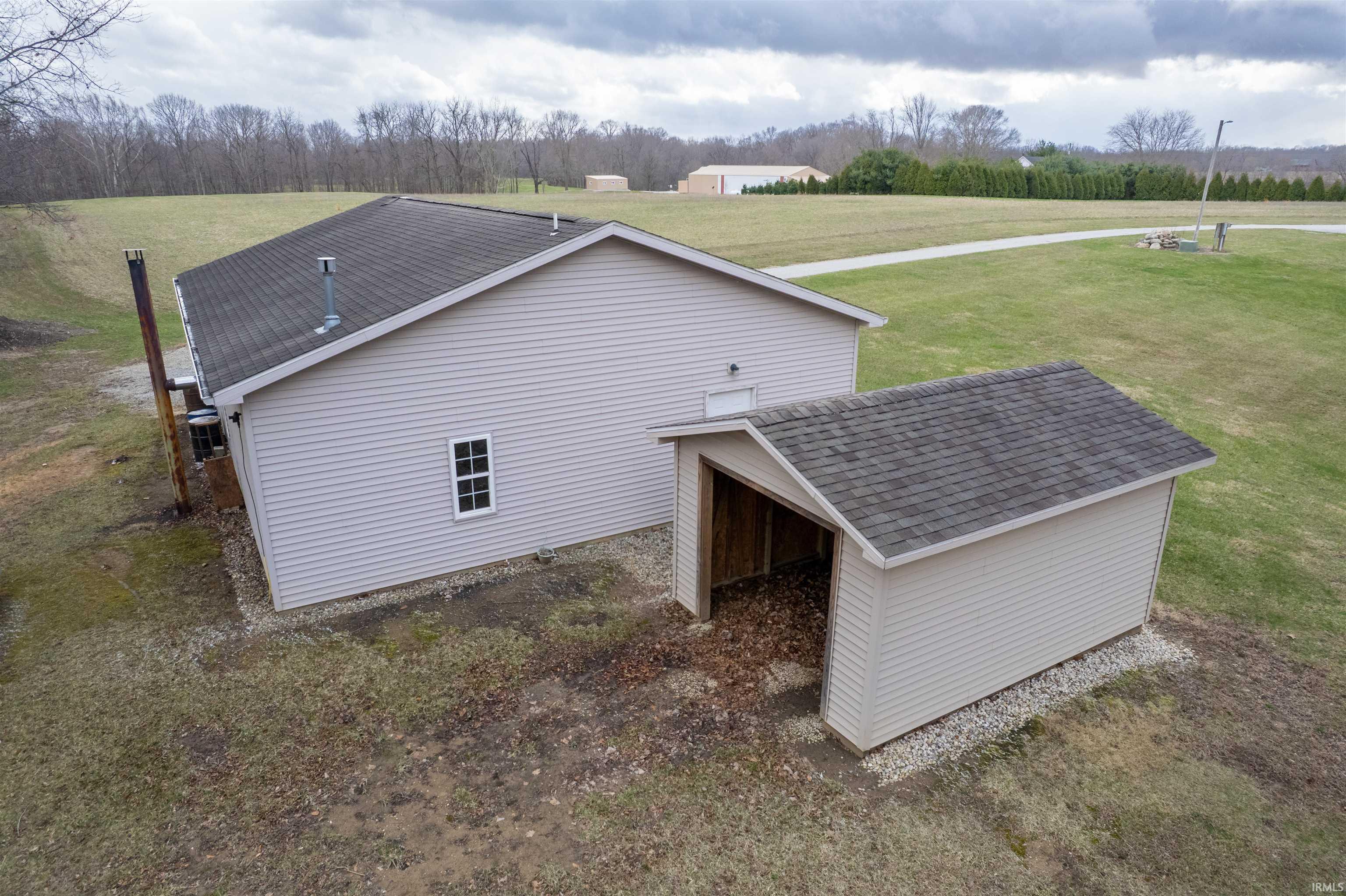 View of home's exterior featuring roof with shingles and a lawn