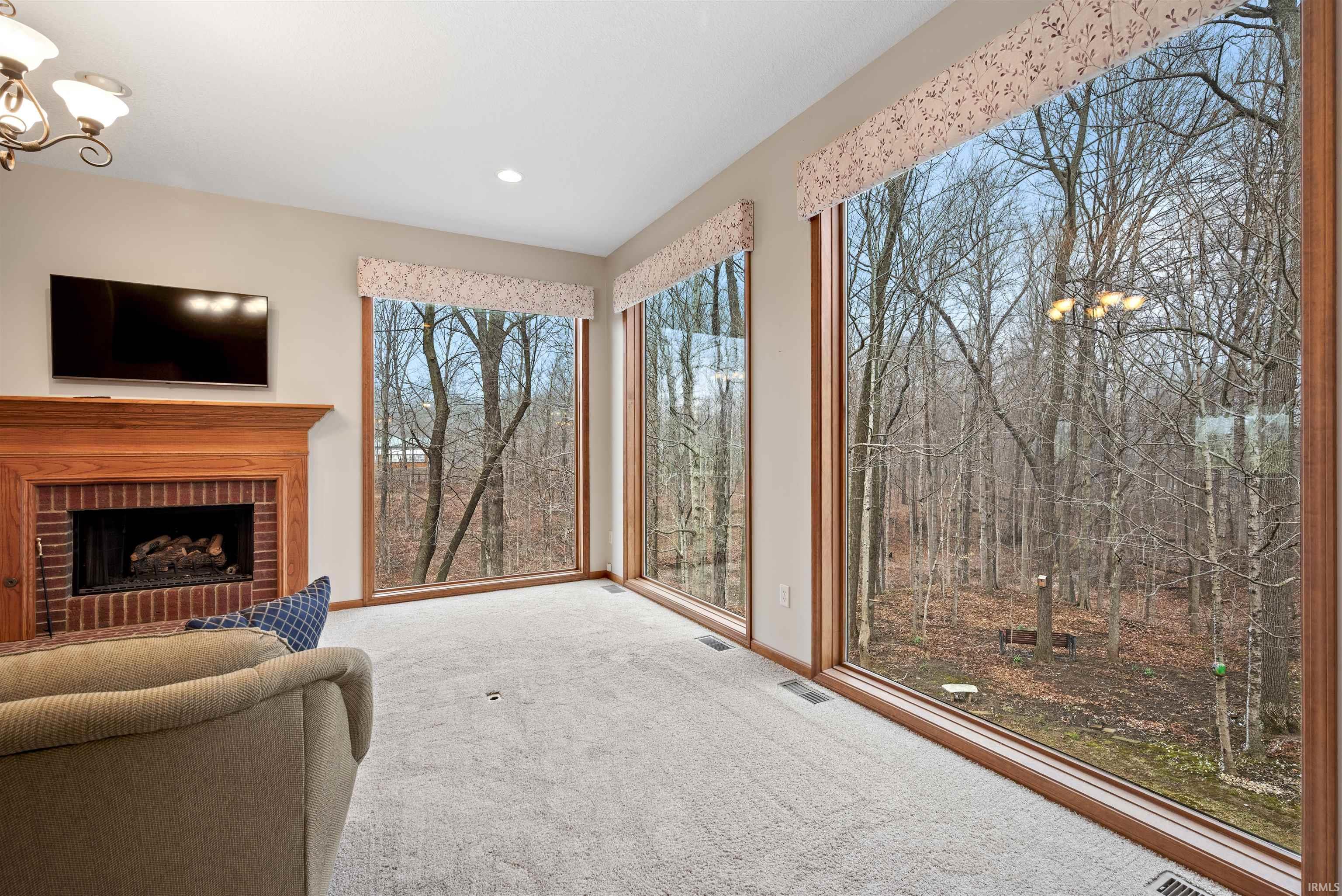Living area featuring a chandelier, carpet flooring, and a fireplace