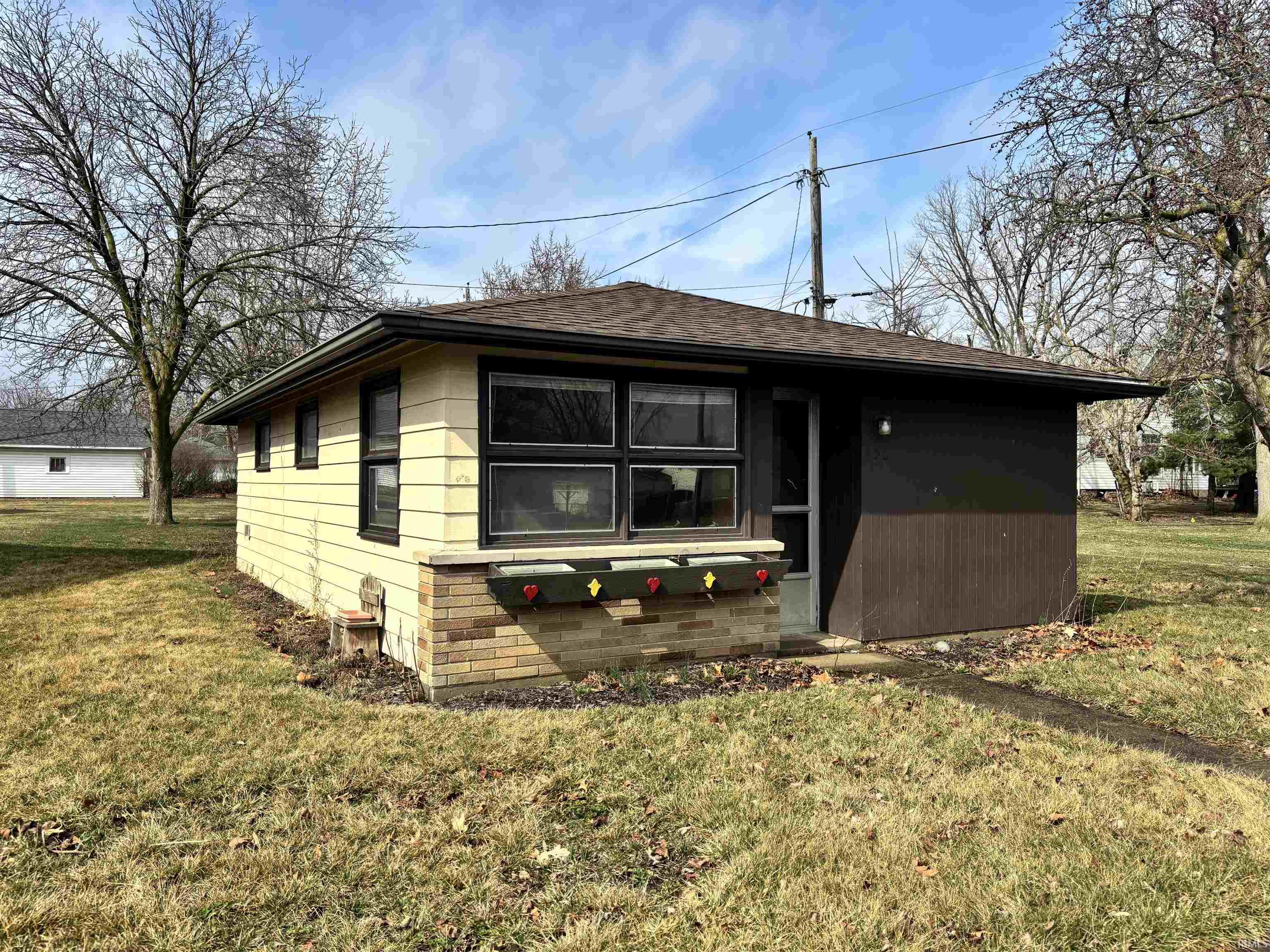 View of front of property with a front lawn and roof with shingles