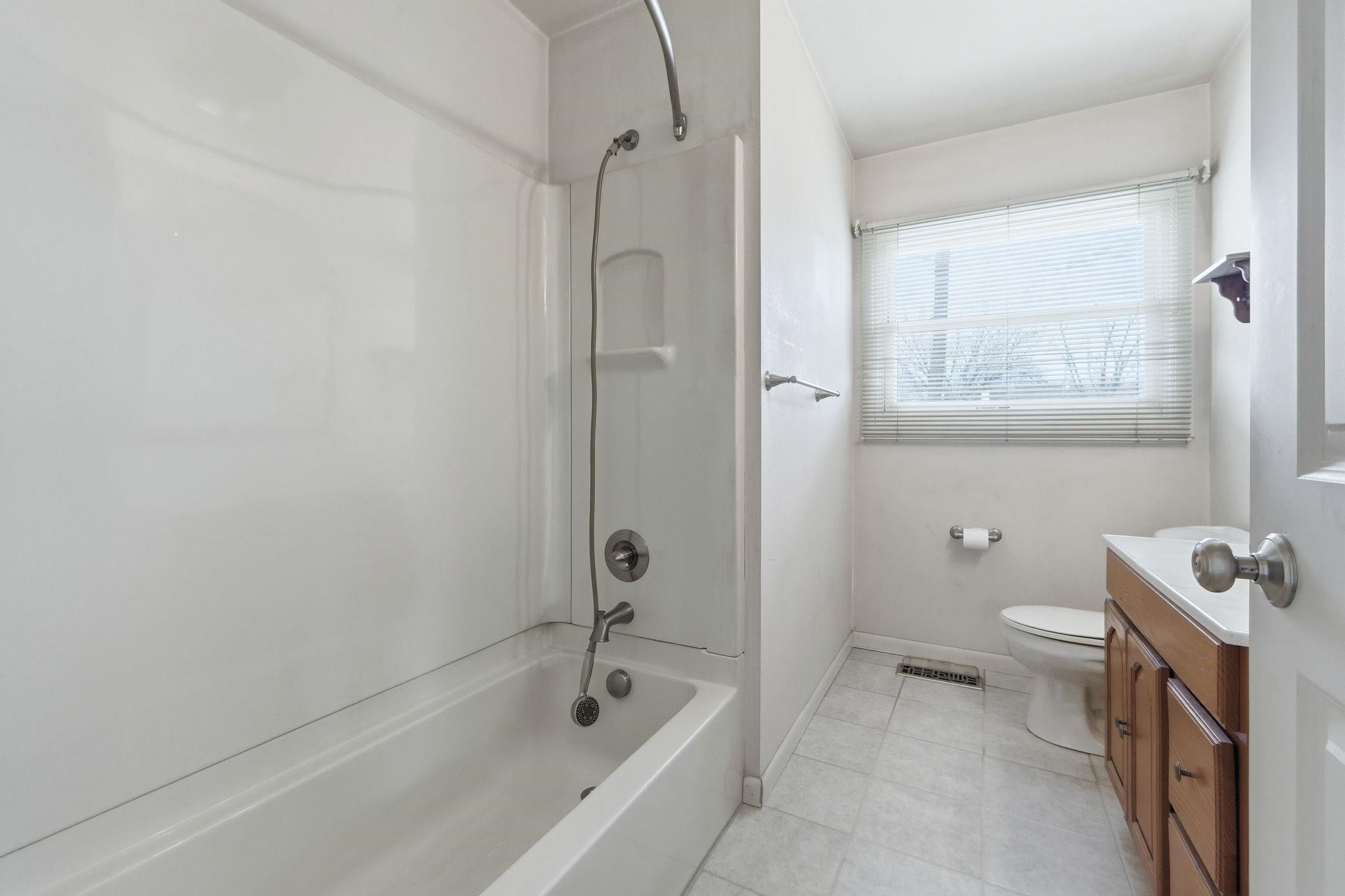 Full bathroom featuring vanity, shower / bath combination, and light tile patterned floors