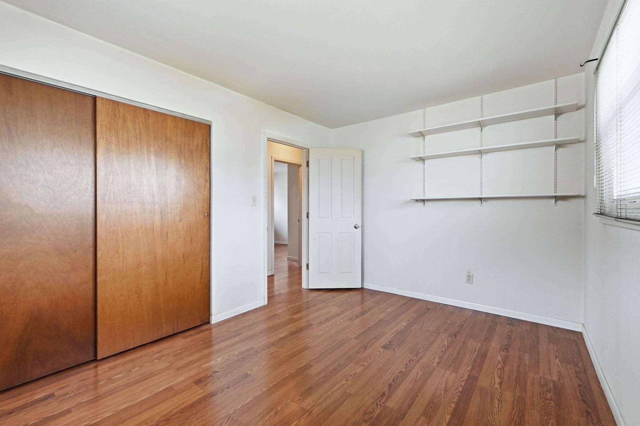 Unfurnished bedroom featuring wood finished floors and a closet