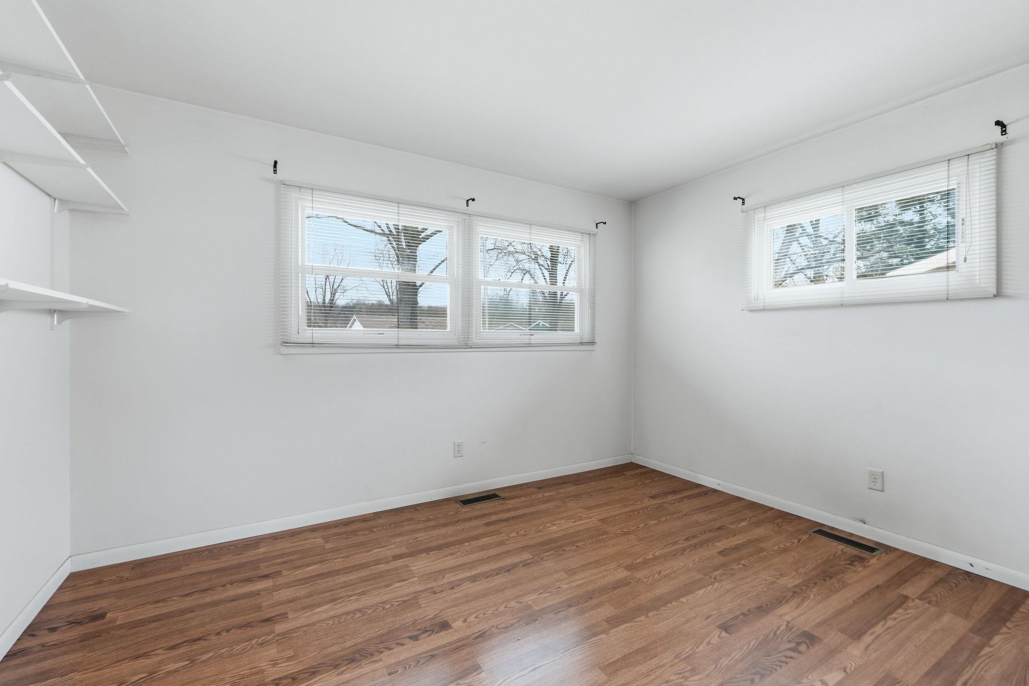 Unfurnished room with dark wood finished floors and baseboards