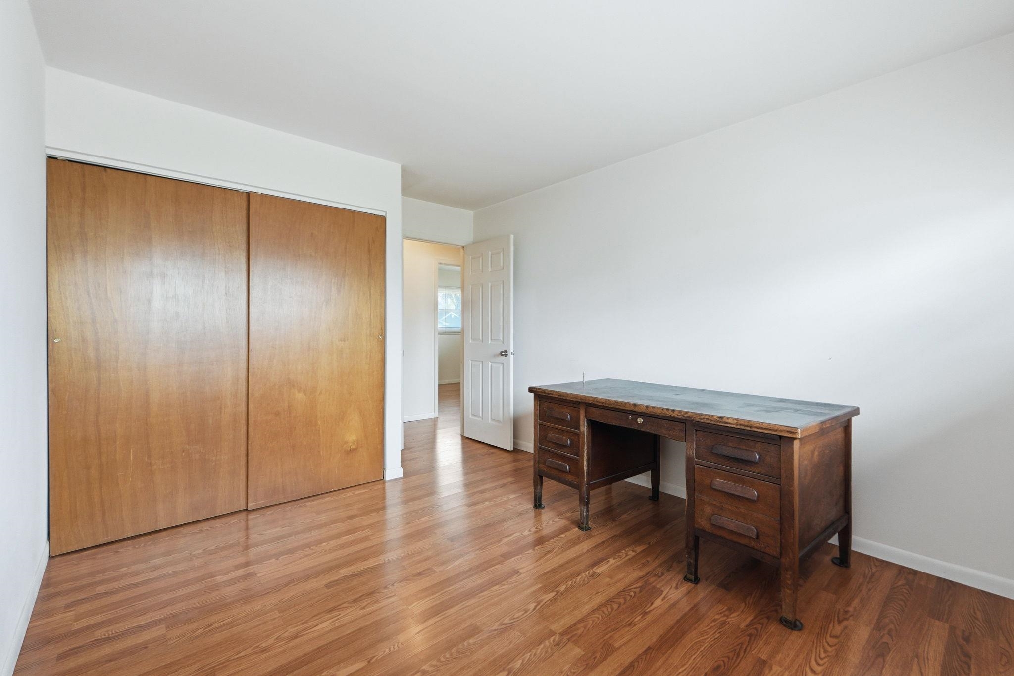 Home office with light wood finished floors and baseboards
