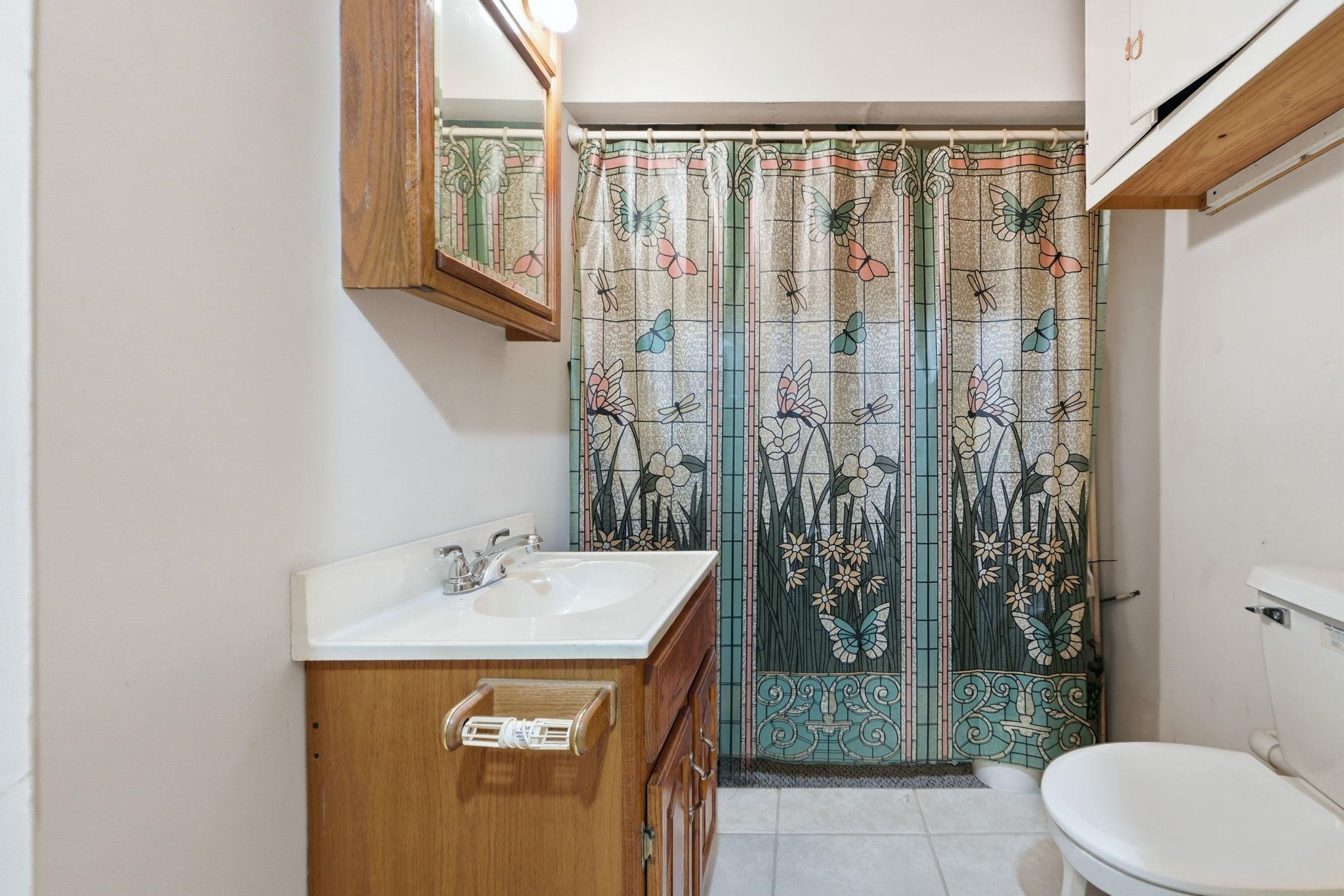 Bathroom featuring vanity, a shower with curtain, and light tile patterned floors