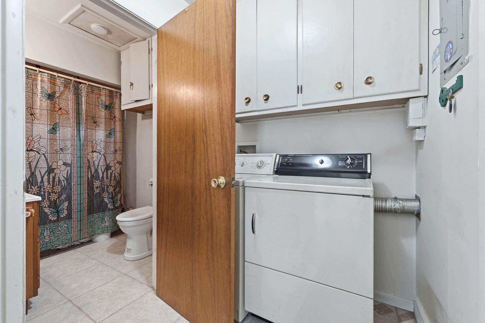 Laundry area featuring light tile patterned flooring and independent washer and dryer