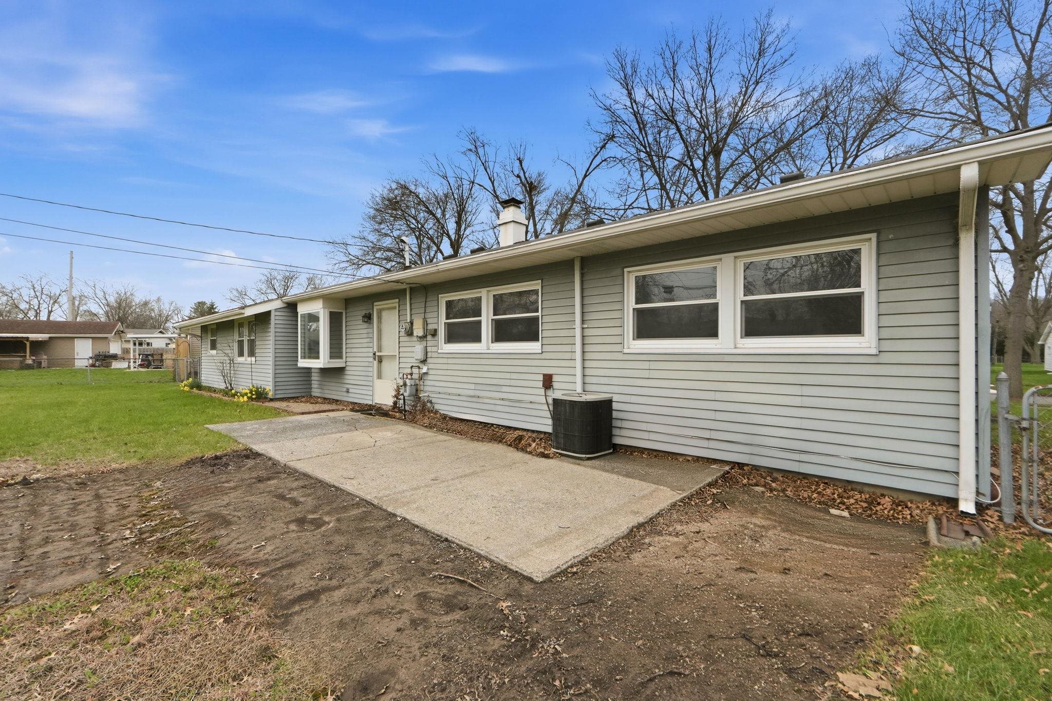 Back of property with a patio area, a chimney, and a yard