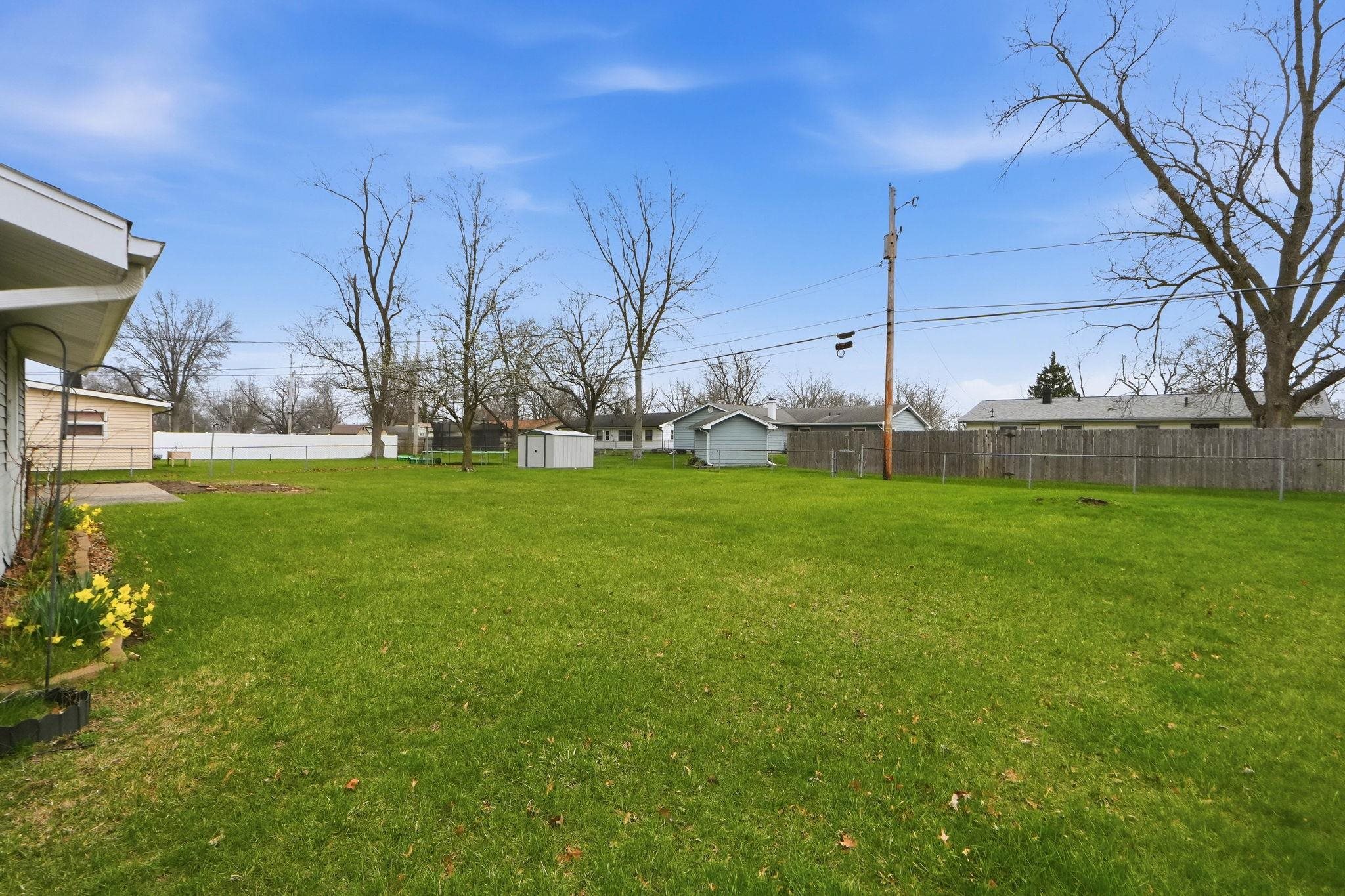Fenced backyard featuring a storage shed