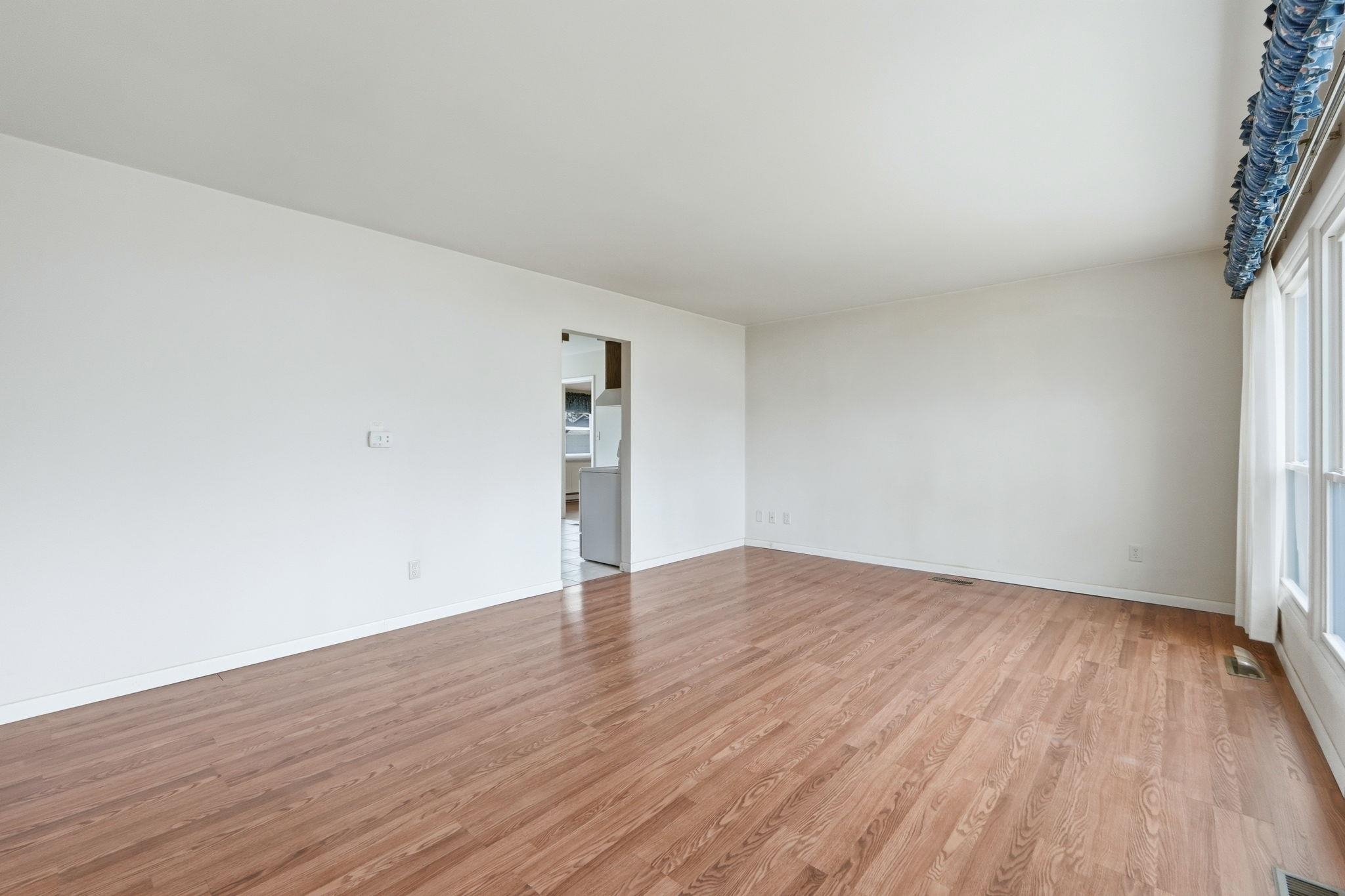 Spare room featuring light wood-style flooring and baseboards
