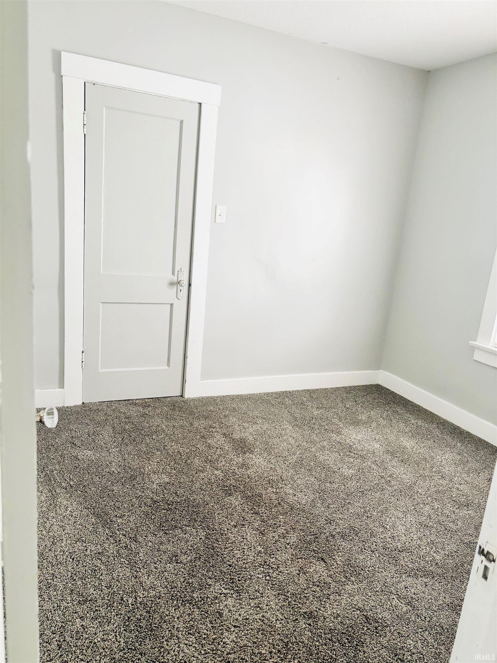 Carpeted spare room with baseboards