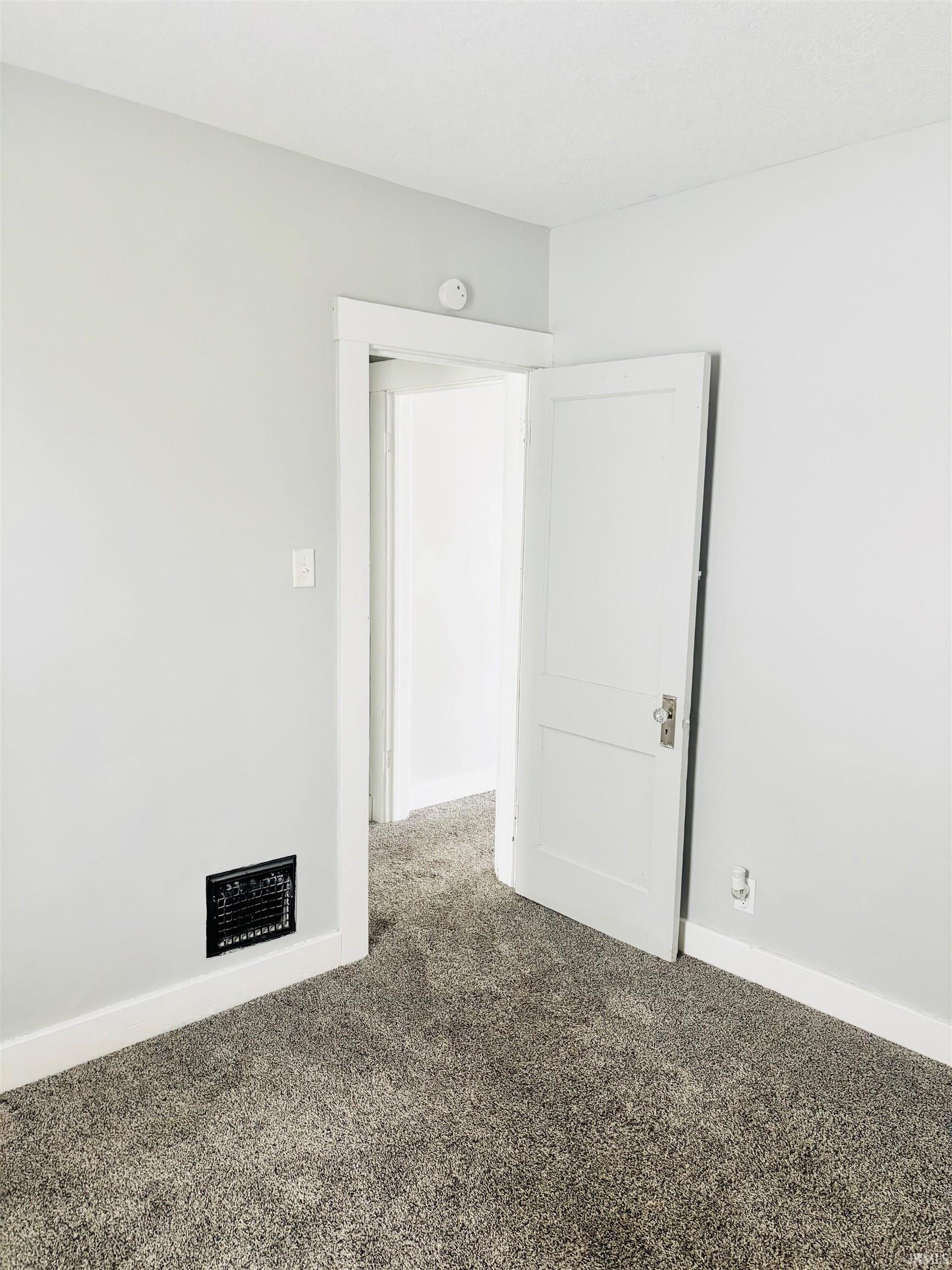 Empty room with baseboards and carpet