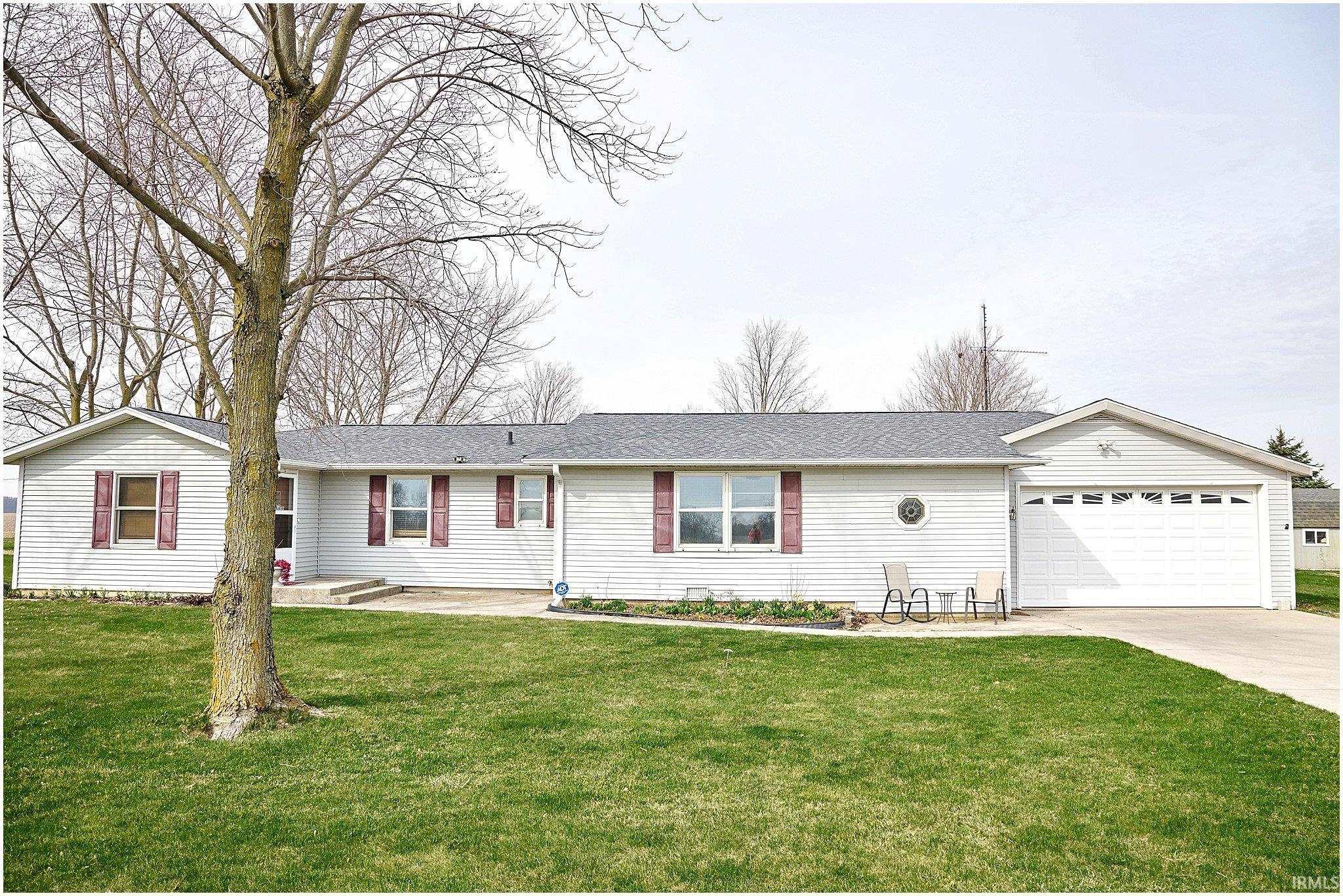 Ranch-style home featuring a front yard, a shingled roof, and concrete driveway