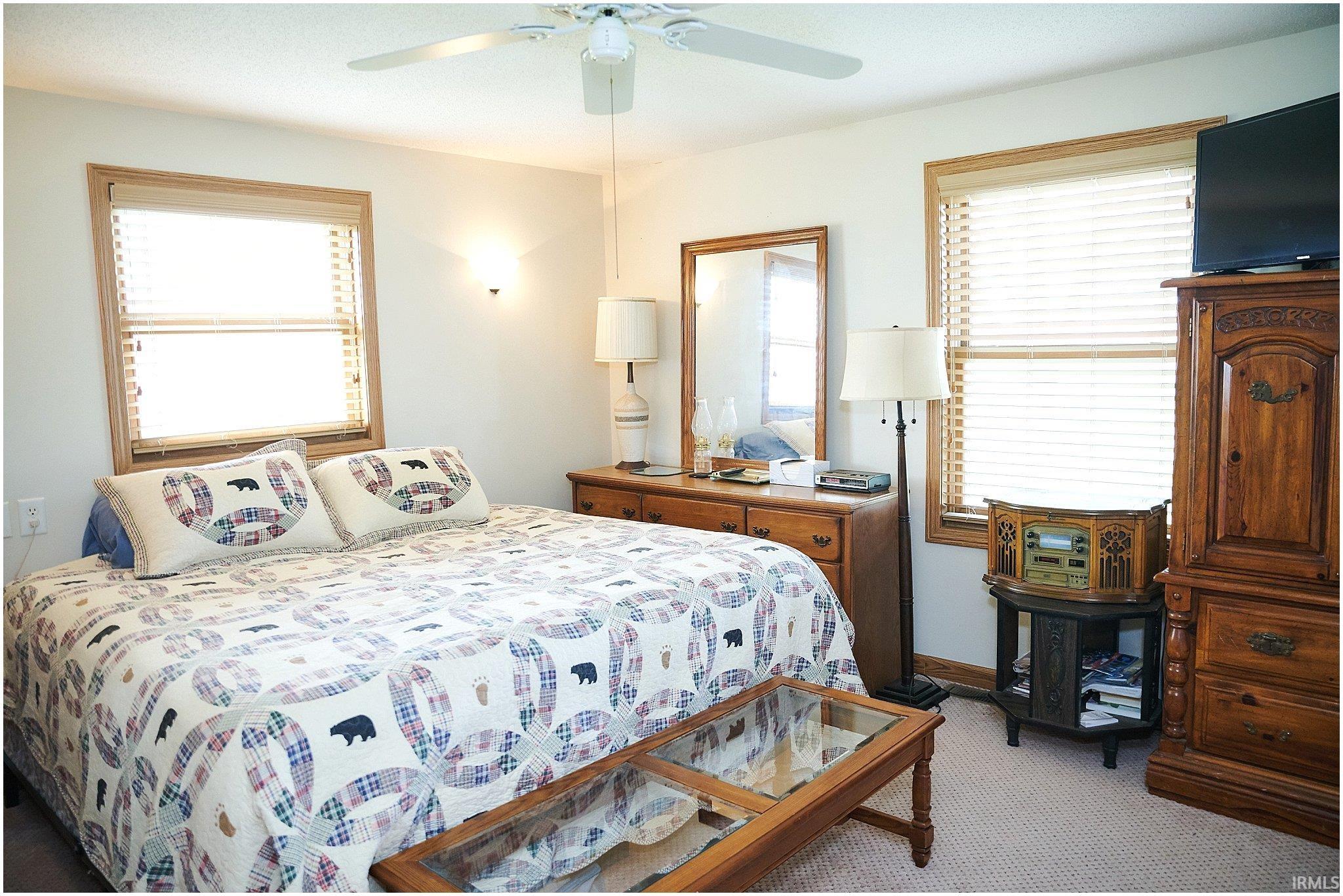 Carpeted bedroom featuring ceiling fan and baseboards