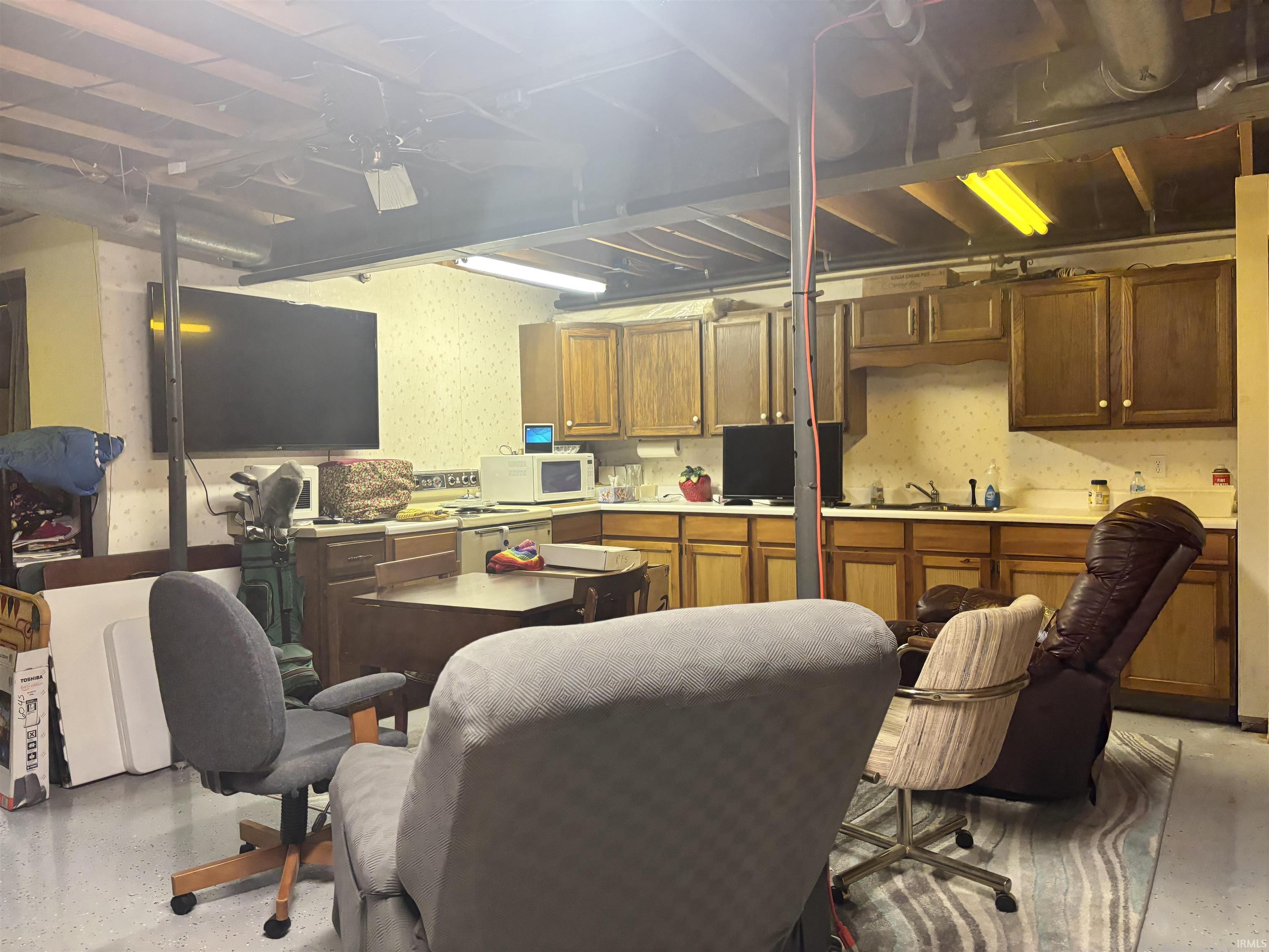 Office area with wallpapered walls and a sink