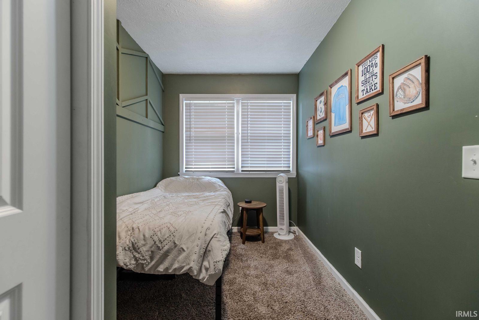 Carpeted bedroom featuring a textured ceiling