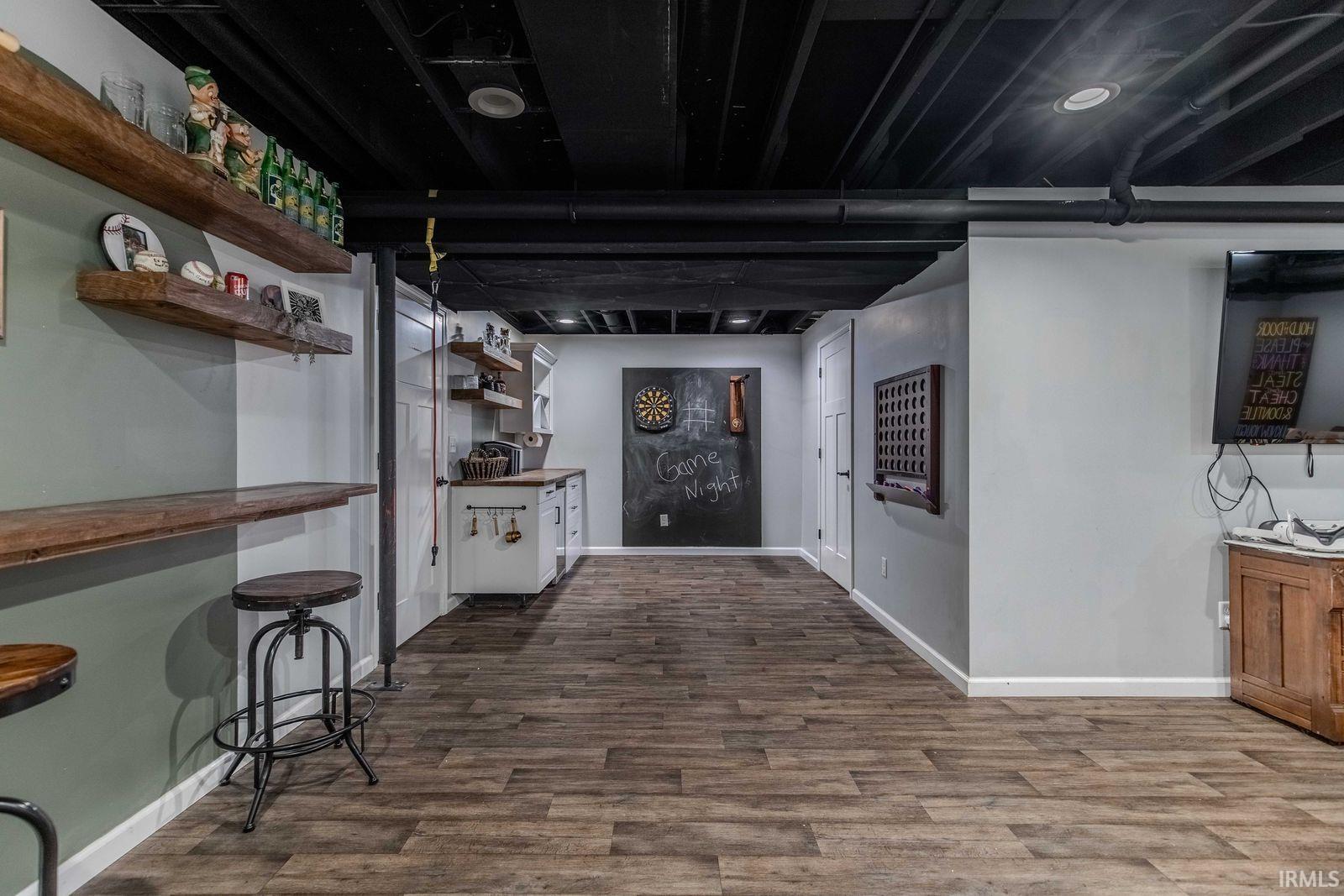 Finished below grade area with dark wood-style floors and a bar