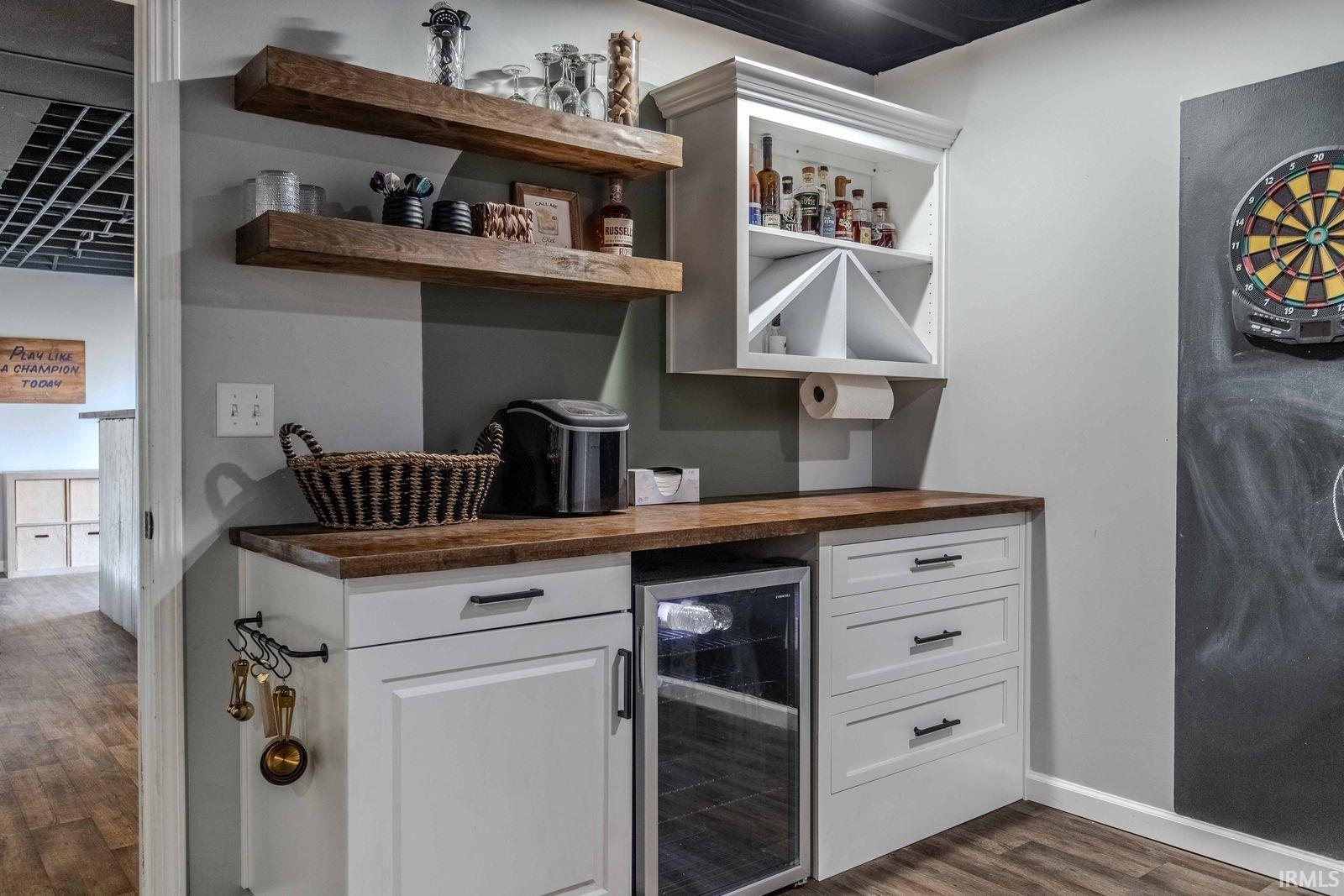 Indoor dry bar featuring wine cooler, white cabinets, dark wood-style floors, and butcher block countertops