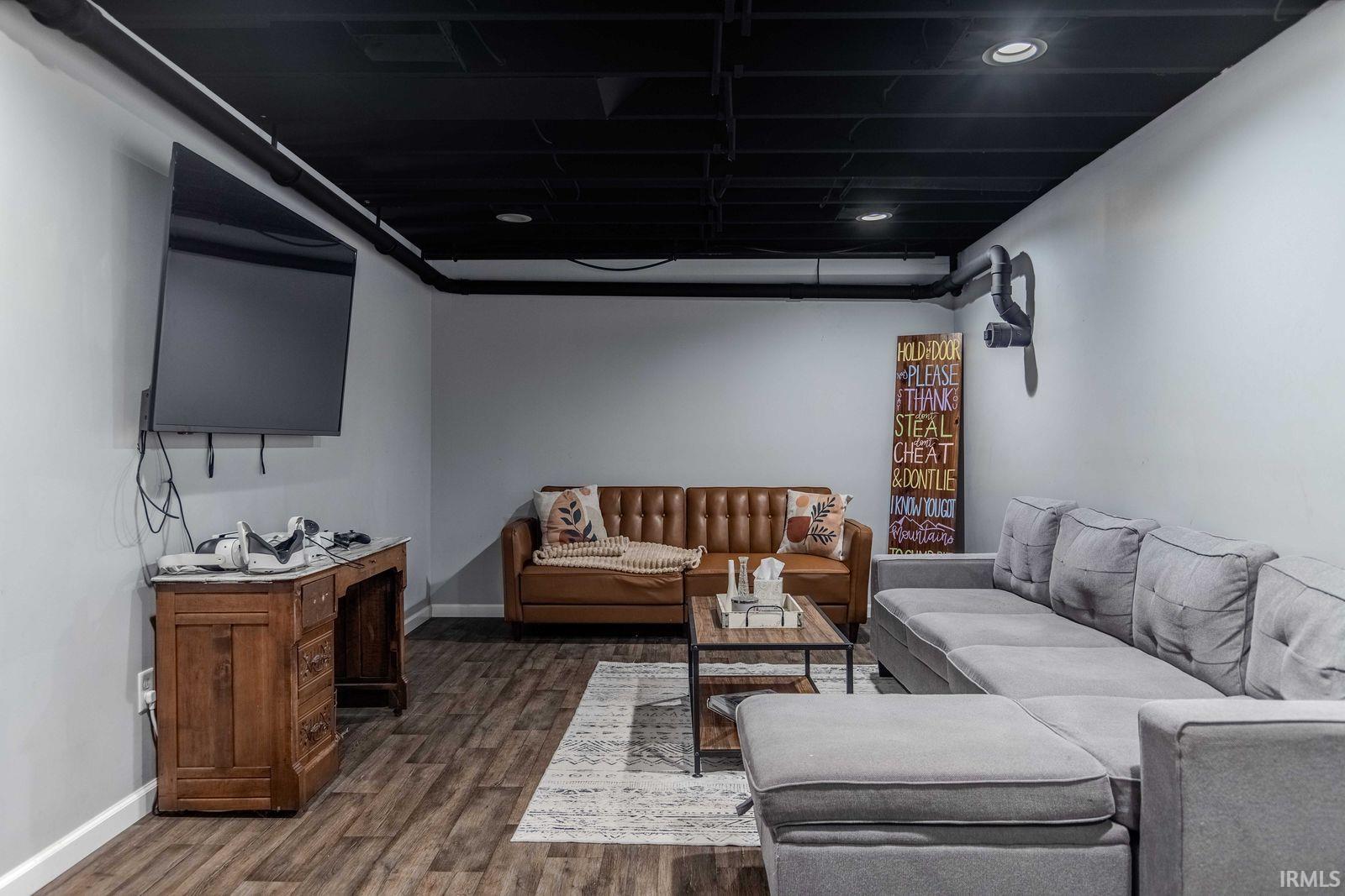 Living area with dark wood-style flooring and baseboards