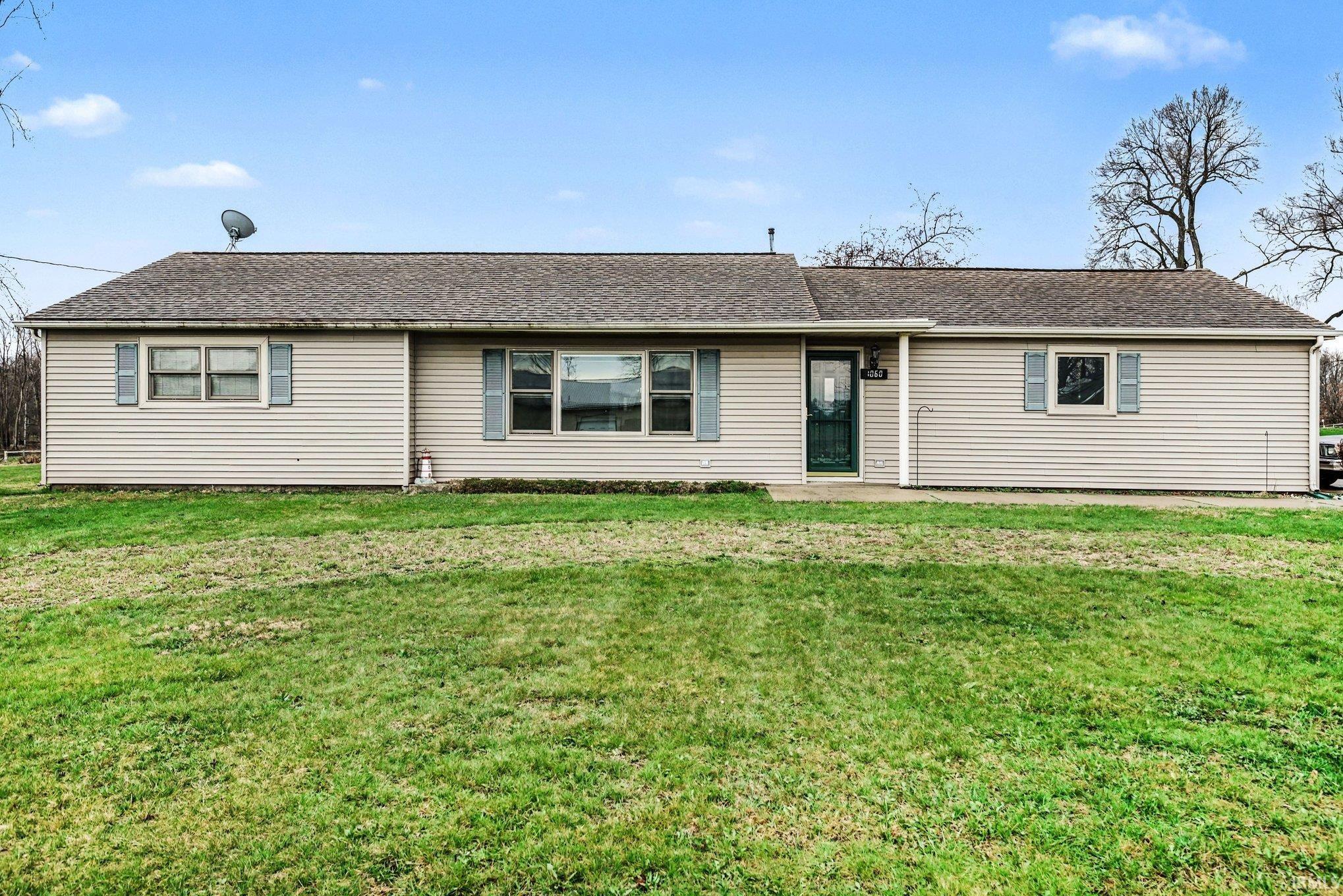 Ranch-style house with a shingled roof and a front lawn